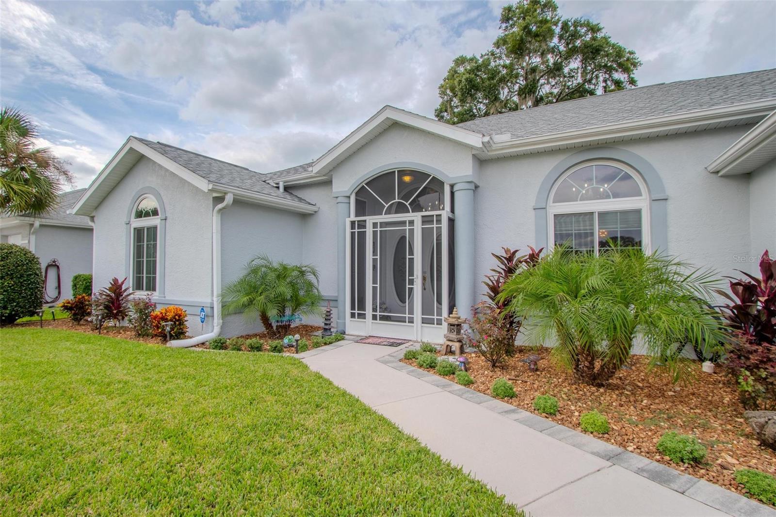 Are you tired of seeing the same cookie-cutter homes and wondering if your dream home even exists? If you’re searching for something truly special—something that breaks the mold—your search ends at 5185 NW 21st Loop. This stunning, professionally landscaped property is unlike anything else on the market. The moment you step through the front door, you're greeted with a dramatic and elegant contrast of creamy whites and bold black accents that immediately set the tone for a one-of-a-kind living experience. Gaze upward to find not one, but two exquisite chandeliers that illuminate the soaring ceilings. Ebony pillars anchor the grand living space, creating an ambiance of sophistication and uniqueness. With an unobstructed golf course view, golf cart garage, and a brand-new roof (2023), this home has been meticulously updated with over $140,000 in improvements. These include new HVAC, paid-off solar panels, new skylight, new windows throughout (except the Florida Room), and beautifully renovated pool and birdcage with a cathedral screen—perfect for year-round enjoyment. The primary suite features tray ceilings, two walk-in closets, and access to the enclosed Florida Room with heat and air for extra living space. Located in a vibrant 55+ active community, you'll have access to a 19,000 sq ft clubhouse, indoor heated pool, fitness center, game rooms, library, and courts for tennis, bocce ball, shuffleboard, volleyball, and more. Golf lovers will enjoy the 18-hole course and driving range. Shopping is just minutes away, and you're less than 2 miles from the World Equestrian Center, with convenient access to both coasts, Orlando attractions, and the airport. This is more than just a home—it’s a lifestyle. Priced at the August 2025 appraised value, this is your rare opportunity to own a distinctive, move-in-ready gem that truly stands apart.