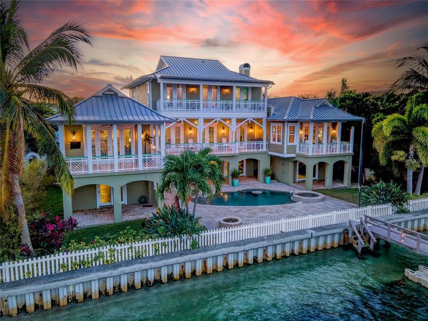 This spectacular Key West inspired home sits on a double lot in Sunset Beach and offers the finest in Coastal Living. With sweeping views from terraces off almost every room in the house you can enjoy the sunrise with a cup of coffee, get a mid-day tan, or eat dinner while watching the sunset. With just two minutes of bridge-free travel to the Gulf of Mexico, the 100 feet of waterfront features a composite dock with electricity and water, with a 13,000-pound boat lift. The dock previously accommodated a 60 ft boat.  
 
As you enter the home through the ten-foot leaded glass door in the grand foyer you will be transfixed by the elaborately detailed cathedral ceilings, exposed beams, fresh new white paint, a grand staircase, and walnut flooring. 
 
The stunning kitchen is a gourmet’s delight featuring a Wolf gas stove with pot filler, a Dacor warming drawer, double Fisher & Paykel ovens, Sub Zero fridge and an expansive solid surface working island with a breakfast bar. The twelve-foot ceilings enhance the natural light that enters this open-plan living and dining space while creating a relaxed coastal atmosphere. An additional living area with a fireplace and formal dining room further establishes the opulence of coastal living. 

The elegant main floor owner’s suite includes an expansive bathing area with soaking tub, walk-in shower, dual vanities, a separate toilet closet, two large walk-in closets, and a washer and dryer alcove with door. A second full size laundry room on the
other side of the house is adjacent to a guest bedroom and full bath.

As you walk upstairs, fall in love with the well-appointed sitting area anchored by an elaborate custom-built in. On one side of the sitting area, you will find a bedroom suite and on the other two additional bedrooms and a full bath.  
 
Relax around the gorgeous, heated Pebble Tec saltwater pool and spa with surround sound.  

Peace of mind comes from living in a solid block, 3 story elevated home with steel roof, high impact windows, 4 HVAC systems, 2 tankless water heaters and a partial home generator. The elevator services all levels of the home beginning at the ground level garage with space for up to 10 vehicles.

Additional noteworthy features include a sprinkler system, central vacuum, Wi-fi hot spots throughout and an enormous amount of storage space throughout the home. Located just one block from the beautiful white sands of Sunset Beach in beautiful Treasure Island.