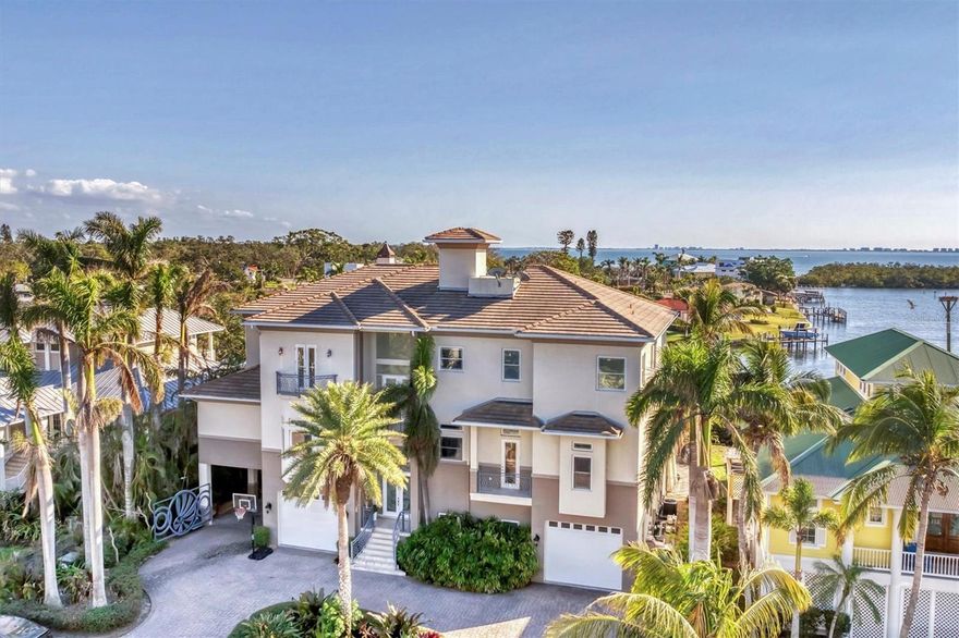 Nestled behind the gates of Hawks Harbor, this unparalleled waterfront estate embodies the epitome of luxury living, offering commanding, panoramic views of the sparkling bay from nearly every room. Masterfully designed to provide both comfort and elegance, this residence seamlessly integrates opulence with the natural beauty of its stunning waterfront setting.
As you step inside, the grandiose 12-foot ceilings and meticulously laid travertine marble floors set the stage for an extraordinary living experience. Every corner is a testament to craftsmanship, with sweeping bay views flooding the open spaces. The expansive family and great room are anchored by a decorative gas fireplace, offering warmth and charm, while disappearing glass sliders open to an expansive covered balcony—creating a seamless connection to the outdoors.
The recently redesigned chef's kitchen is a masterpiece, featuring an oversized quartz island with a sleek stainless-steel prep sink, a state-of-the-art Wolf double oven, a five-burner DCS gas cooktop with griddle, and a Sub-Zero refrigerator/freezer. Floor-to-ceiling windows frame a spectacular, ever-changing backdrop of tranquil bay waters.
For those who love to entertain, this home excels. An opulent eight-seat theater room with a marble bar, a custom-designed game room complete with a bar and a second-floor wet bar with both refrigerator and dishwasher, giving endless opportunities for indulgence and enjoyment.
The master suite is nothing short of extraordinary—a serene private sanctuary with full bay views, a lavish dressing room with custom-built storage and a granite-topped island, and a spa-inspired bath with a steam shower, rain shower, elevated garden soaking tub, and dual vanities. The wrap around balcony on the third floor and rooftop crow’s nest balcony give an ideal vantage point for savoring dramatic sunrises and sunsets over Longboat Key.
The outdoor living spaces are nothing less than spectacular. Designed by Lucas Lagoons and featured on Animal Planet’s Insane Pools, the two-story pool features a stunning mosaic stone waterfall that cascades into an infinity-edge pool. A summer kitchen, and custom outdoor shower elevate this space into a true resort-like oasis.
For the boating enthusiast, this estate is unparalleled, offering two private docks, including a 15,000 lb. lift and a secondary dock equipped with a kayak and Jet Ski lift on a moveable track—ideal for all of your aquatic adventures.
Additional exceptional features include hurricane-rated windows, a four-stop elevator, an invisible dog fence, a tankless hot water system, a central vacuum, water softener, and a golf cart garage. Just minutes from Sarasota Bay’s open waters, this extraordinary home offers the perfect combination of privacy, exclusivity, and ultimate waterfront living at its finest.
This estate redefines the standard for opulence, comfort, and sophistication—creating an experience that is truly second to none.