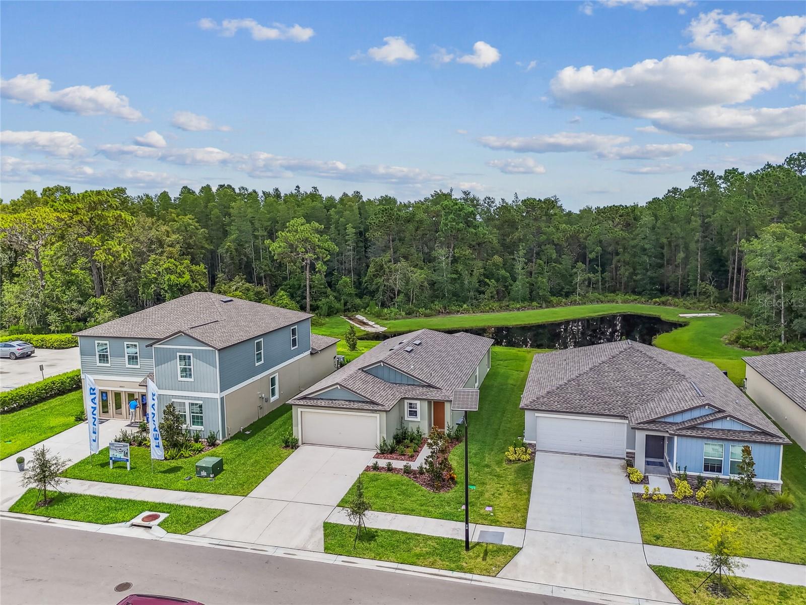 FORMER BUILDER MODEL – NEVER LIVED IN – This bright and airy single-story home is situated on a desirable POND AND CONSERVATION LOT in the master-planned community of Angeline and is within walking distance to the new Angeline Country Day School. Offering 3 bedrooms, 2 bathrooms, and an open layout, the home features WOOD LOOK TILE FLOORING THROUGHOUT ALL MAIN LIVING AREAS, with carpet in the bedrooms. The spacious kitchen showcases an OVERSIZED QUARTZ CENTER ISLAND WITH SINK, white cabinetry, and stainless steel appliances, flowing seamlessly into the dining and family rooms—ideal for everyday living and entertaining. The owner’s suite includes a private ensuite with dual sinks, a walk-in shower, and a LARGE WALK-IN CLOSET, while two additional bedrooms provide space for guests, family, or a home office. Angeline spans over 6,200 acres and will offer a future Metro Lagoon, STEM magnet school, community farm, 100 miles of trails, and Moffitt Cancer Center’s 775-acre Speros FL campus. With 3,600 acres of green space and easy access to the Suncoast Parkway, Tampa Premium Outlets, and AdventHealth Connerton, this home combines comfort, nature, and convenience in one exceptional location.
