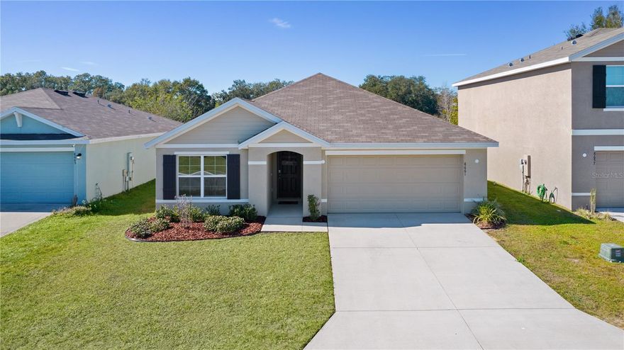 2022 ARIA Model – Concrete Block 3BR/2BA with 2-Car Garage in Quiet Triumph South, Wildwood!
Built in 2022, this move-in ready home offers 1,664 sq ft of open floor plan living with ceramic tile in main areas and plush carpet in bedrooms. The chef’s kitchen features granite countertops, a large island with sink, stainless steel appliances, and a walk-in pantry.
The private primary suite includes a huge walk-in closet and an en suite with dual vanities, an oversized walk-in shower with rain head, a separate water closet and a second closet where you can keep your need everyday items. A desirable split-bedroom layout provides privacy, with two guest bedrooms and a full bath in their own wing.
Enjoy indoor laundry, a covered lanai, and a private, vinyl-fenced backyard with no rear neighbors—ideal for relaxing, pets, or even adding a pool. Located in a low-traffic community with its own park/playground.
Conveniently near The Villages, shopping, dining, Town Squares, and new retail including Lowe’s, Target, Chipotle, Costco, Walmart & more. Situated in a growing area with strong rental demand, making it ideal for full-time living or investment.