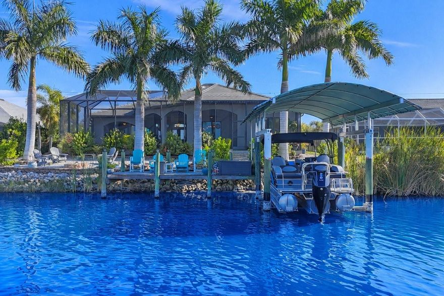 Don’t miss this rare opportunity to own a true piece of Florida paradise in the highly desirable Waterfront community of South Gulf Cove. This move-in-ready, upgraded Waterfront Pool home, built in 2018 with a 3-car garage, offers an exceptional blend of luxury, comfort, and Florida lifestyle living.

The bright, open-concept floor plan seamlessly connects the living room, dining area, and gourmet kitchen, making it ideal for everyday living and entertaining, hosting parties is a breeze with seating for 45 guests. Expansive 10’ zero-degree sliding glass doors fully open to the lanai, creating a seamless indoor-outdoor living experience.

The chef’s kitchen features granite countertops, an undermount sink with retractable sprayer, sleek finishes, a large pantry, and a rare coat closet. The private primary suite offers 2 walk-in closets, peaceful water and pool views, and a dual-entry spa-style walk-in shower. Additional interior highlights include tray ceilings, crown molding, soaring 11’9” ceilings, and wood-plank ceramic tile flooring throughout.

Outdoor living is a standout feature, with a heated saltwater pool offering a sundeck, shelf seating, fountain, and new pool pump (10/2025). The expanded lanai features raised ceilings, architectural arches, stacked-stone accents, three ceiling fans, and hurricane shutters, providing ample space for entertaining. The outdoor kitchen is fully equipped with a Bullet grill, wine refrigerator, range hood with backsplash, TV, and a fire pit overlooking the water.

Boating amenities include a 10,000-lb boat lift with water and electric, new Waterway boat cover (2025), and a 10’ x 20’ Trex dock. Situated on a three-way canal intersection, the property offers excellent access for boating, kayaking, and paddleboarding.

Additional features include a triple-wide paver driveway, slate tile roof, public water and sewer, hurricane-impact windows and shutters (front entry and lanai), Rain Bird irrigation system with new pump (10/2025), extra-tall pool cage (10’ sides, 14’ center), fenced dog run, queen palm landscaping with low-maintenance shell ground cover, outdoor shower, spacious garage with ToughBuilt cabinetry, and an indoor laundry room off the garage.

Conveniently located just minutes from Boca Grande, offering access to world-class fishing, dining, shopping, and Gulf beaches. This property truly captures the best of Florida waterfront living.