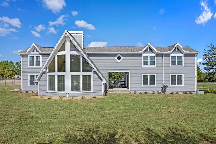 Located at the quiet end of Johns Lake Road, enjoy COUNTRY living roughly 5 MINUTES from SHOPPING & RESTAURANTS! This contemporary farmhouse offers a living room with a “wall of windows” reaching 22' high allowing tons of natural light to enter with a wood burning fireplace to keep you warm on those cold winter nights. There are 4 BEDROOMS with 4 BATHS, a cabinet filled kitchen, the lower cabinet shelves all pull out for ease of reach, with an abundance of countertop space incorporating a huge breakfast bar..The dining room is right around the corner allowing the smells of a fabulous meal to drift in, Yummy! There’s also a bedroom and full bath located on the first floor allowing privacy for guest. At the top of the staircase, you’ll find French doors that open to the massive owner's suite featuring an ensuite that includes dual sinks on the long vanity, a jetted tub, separate shower and walk in closet. From there, stroll down the spacious hallway past the upstairs OFFICE to find a TWO sizable bedrooms, another bathroom with dual sinks vanity, shower/tub combo and linen closet and a sitting room. The BREEZEWAY is a wonderful outside relaxation area located between the front door and a HUGE 768 square foot room above the garage with its own air conditioner, LOTS OF SUNLIGHT, a bath with a sizable shower which would make an amazing IN-LAWS SUITE, game room, family room, movie theater...the opportunities are endless. This (almost) 5 ACRES of peaceful horse property features two pastures and is completely FENCED with 2"X 4" non-climb horse fence and has an electric driveway gate offering a secure home for you and your critters. The back pasture includes a 4 stall center aisle barn that has stall fans and automatic waterers. In the front field you'll find TWO more stalls, one enclosed to confine your smaller animals/birds for protection from the elements. There's an air-conditioned storage building that needs attention but has been the feed and tack room for 25+ years and a shipping container that was modified for better air flow used for hay storage. Situated just after the stop sign on the quiet section of the road where neighbors still walk and ride bikes, your dream home awaits.