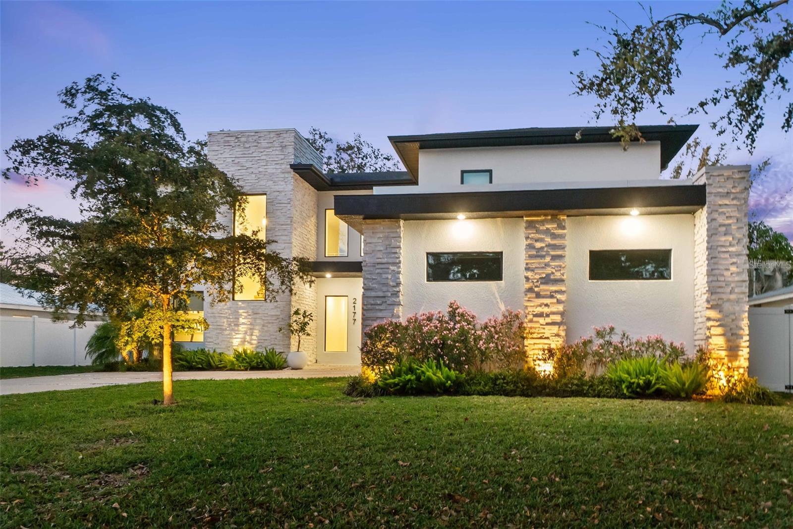 Simply stunning - this newer construction luxury home in Sarasota is nestled perfectly between Southgate, Arlington Park and Cherokee Park and is walking distance to Southside Elementary school. The entirety of the 5,461 square feet of total living area is a contemporary masterpiece offering expansive open-concept living spaces flooded with natural light and subtle sophistication. The exterior boasts a sleek, minimalist design, featuring a blend of clean lines, large glass windows and natural stone. An attractive, welcoming front door opens to a breathtaking, soaring entryway where the striking natural wood floors draw the eye further toward the dramatic, floating staircase framed by modern metal railings. The state-of-the-art kitchen is equipped with top-tier finishes, including Thermador appliances, a climate controlled 300-bottle wine cellar, custom cabinetry and a massive island draped in quartz countertops. Staying organized and tidy while cooking for you or a crew is simple in the oversized pantry with appliance storage and prep countertops. Entertaining is a breeze with conversation flowing throughout the spacious yet cozy living area, flanked by oversized glass windows with views of the tropical courtyard, the invitation to step through the glass sliders to the expansive outdoor patio and backyard oasis. Serve your coastal cuisine indoors or outdoors as the patio offers an additional al fresco cooking space overlooking the spa and pool boasting crystal blue water sprawling between the dual covered patios. Refresh from your dip in the pool in the outdoor shower and cabana bath. After a day of outdoor adventure and relaxation, the nightly feature can take place in the dedicated home theater with a 4k projector and 10 surround sound speakers. This home offers first and second floor primary suites and two additional, generously sized bedrooms. The primary suites offer luxurious, spa-inspired baths while the additional bedrooms each access a full bath. The two-car side load garage is convenient, the professional landscaping and accent lighting in and around the home create an opulent ambiance, while the 20-seer, 4-Zone Infinity HVAC system will keep your cool in the Florida summers. Custom comforts and peace of mind are integrated throughout with a 21-foot elevation above sea level, hurricane-rated impact windows and doors, mosquito misting system, luxury fixtures and finishes, smart home technology and level 5 drywall finish. With ideal proximity to shopping, dining, premier beaches and the best of Florida’s golf courses and outdoor recreation, this dream home offers the perfect blend of modern amenities, casual comfort and the ultimate coastal lifestyle.