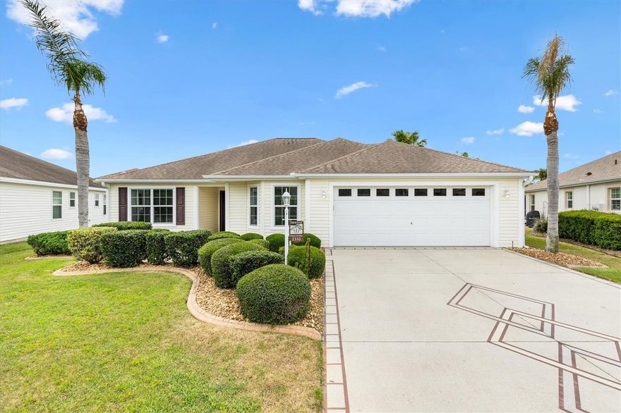 3/2 Wisteria Designer Home in the Village of Tamarind Grove perfectly situated between Lake Sumter Landing and Brownwood Town Center. This beautifully designed property features an irregular-shaped lot and a charming covered front entry with decorative frosted glass front door and side panel. Inside there is tile flooring in the main living areas and wood-look laminate in the bedrooms, complemented by ceiling fans with light kits for year-round comfort. 
The eat-in kitchen is both functional and stylish, featuring a breakfast bar, dedicated coffee bar, glass subway tile backsplash, stainless steel appliances, pull-out cabinets, and a pantry cabinet, making it perfect for culinary enthusiasts. 
Designed with privacy in mind, a pocket door separates the guest area, where you’ll find comfortable bedrooms and a shared bath with a tub/shower combination and a window for natural light.
The spacious master suite offers a relaxing retreat with a large walk-in closet and an ensuite bath complete with dual vanities, a Roman walk-in shower, linen closet, and a window for added brightness. The extended garage has plenty of room for 2 cars and a golf cart. 
Enjoy Florida living at its best as sliding glass doors from the living room open to a screened lanai, leading to an outdoor patio and surrounded by a privacy hedge—perfect for relaxing or entertaining. Additional highlights include an inside laundry room with storage closet and utility sink, attic stair kit, a new garage door, knock down ceilings, and solar tube in the dining room for adding natural light to the home. Within a mile from this home are 7 pools and 5 executive Golf Courses. Cane Garden Country Club and Golf Course is just 1.5 miles away.
A golf cart is available separately, and furniture/turnkey package is also available separately, making this home as flexible as it is appealing.
Be sure to watch our virtual tour of this wonderful home and schedule your appointment to see it today so you can start living The Villages dream.