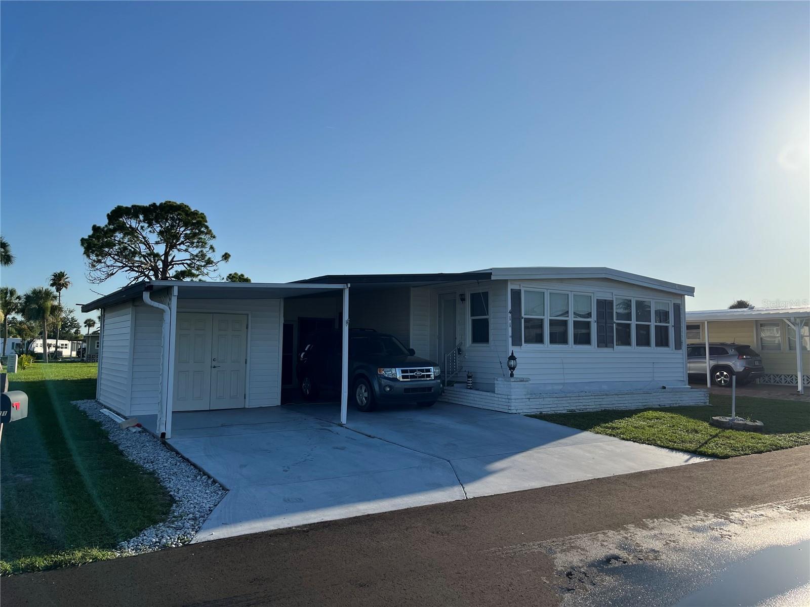 A huge home with side-by-side parking AND a new golf cart garage, New carport. Newer windows, repiped supply Plumbing, Vinyl siding, New hot water heater, Tons of closet space in the hall and both bedrooms.. Newer master and guest bath vanities and shower enclosures, Florida room with Plexiglas windows on the drive side adds even more square footage, A Huge shed gives ample storage and work space for the crafters.