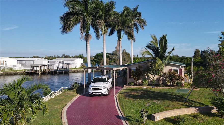 Discover your piece of paradise with approximately 240 feet of waterfront on scenic Shell Creek! This property has lots of potential and is ready for your finishing touches! Enjoy the four mature Royal Palm trees, elegant stone landscaping and recently installed new rip rap. Spend your days on the water with your private boat lift and dock—perfect for fishing, boating or grilling up the day’s fresh catch. When it’s time to relax, unwind under your cozy Tiki hut, ideal for sipping your morning coffee or evening cocktails while soaking in the waterfront views. Inside, this triple-wide home offers a blank slate ready for your personal design. The property previously sustained minor flooding (approximately 1.5 feet), which has since been repaired. Additional features include a newer metal roof, new refrigerator and range, and new flooring and molding materials already purchased and ready for installation. This is the perfect opportunity to create your dream waterfront retreat exactly the way you envision it!