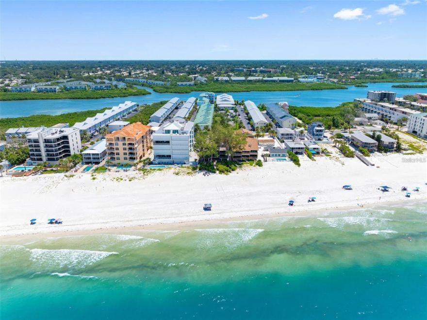 One or more photo(s) has been virtually staged. Auction Property. WELCOME TO YOUR FRONT ROW SEAT TO PARADISE!  THIS BEACHFRONT CONDO IS TRULY A ONE-OF-A-KIND HIDDEN TREASURE!    Indulge in the ultimate coastal escape where sunshine and crystal sand are literally steps away from your private deck with breathtaking DIRECT VIEWS OF THE BEACH AND THE GULF!   This rare gem is an end unit within an intimate and unique 8 unit building and includes 2 covered carports.  The beachfront deck spans 195 sq. ft. and offers the perfect vantage point to watch spectacular sunsets and relax and savor the peacefulness of gentle gulf breezes and stunning water views.  The expansive living room features wood flooring, a cozy fireplace, a wet bar and a mirrored accent wall creating an inviting atmosphere for entertaining guests.   The kitchen has tiled countertops, an abundance of cabinet space, including wine racks.   The impressively large primary bedroom retreat is equipped with built in dressers and closets, plus an enormous walk-in closet with ample storage!  For a spa experience, the primary bath has a soaking tub and walk-in shower.   You'll love the convenience of a washer and dryer closet in the hall, a spacious storage area under the foyer staircase, and under building storage for kayaks/canoes.  The roof was replaced in 2021.  This property offers exceptional flexibility whether you’re seeking a part-time or full-time haven, considering a seasonal rental or are a savvy investor with its pet friendly policy and minimum 30 day rentals.  Residents and guests will appreciate the ease of everything within walking distance or can hop on the Jolley Trolley to visit  shops, boutiques, casual and fine dining, pubs with music, miniature golf, tackle shops, parks, boat ramps, fishing charters, jet ski rentals and more!   Just a 40 minute drive to I-275 and Tampa International Airport and 30 minutes from St. Pete-Clearwater Airport.   Milestone Inspection Report and Structural Integrity Reserve Study have been completed!  It's time to embrace each day with salt-kissed air, calming vibes and Wake Up to Paradise!