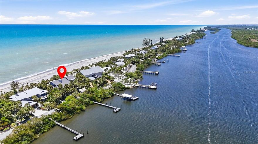 Positioned on the coveted north end of Manasota Key, this extraordinary Gulf-to-Bay estate offers nearly an acre of private coastal living with approximately 100 feet of direct Gulf frontage and serene bay access along Lemon Bay. Designed to capture sweeping water views and effortless elegance, the residence features four spacious bedrooms—all with walk-in closets—and four full baths, including two luxurious upper-level primary suites overlooking the Gulf. The main living areas showcase soaring cedar ceilings, travertine flooring, a wood-burning fireplace, and an expanded living room that frames breathtaking sunsets. A chef’s kitchen anchors the home with a gas range and hood, Sub-Zero refrigerator, double convection ovens, granite surfaces, and an oversized island ideal for entertaining. Thoughtfully designed for flexibility, the layout includes a first-floor den with private bath, a second-floor office with French doors and Gulf views, and a generous bonus/family room. Modern upgrades include full hurricane protection, three new A/C systems (2025), a buried propane tank, and two refrigerated wine closets. Outdoors, Ipe decking surrounds the home, while a newly constructed composite dock (2026) on the bay side is plumbed for water—perfect for embracing the ultimate waterfront lifestyle. Located within a gated enclave along a private two-mile road, this beachfront sanctuary offers rare seclusion just moments from dining, marinas, and golf, delivering an unparalleled blend of tranquility, sophistication, and refined coastal living.