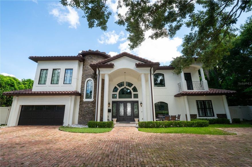 Step into elevated Winter Park living with this exceptional Mediterranean-inspired estate. Built in 2020, every inch of this home was thoughtfully crafted with timeless architecture and sophisticated, high-end finishes. From the rounded stone entry feature and custom iron double doors to the soaring ceilings and designer lighting, this home instantly impresses. The spacious great room opens to a wall of glass folding doors that reveal a private backyard retreat—featuring a heated pool and spa, lush landscaping, and an expansive lanai with summer kitchen. The home is serviced by natural gas, seamlessly supporting modern comfort and efficiency. The kitchen is truly the heart of the home, boasting dual oversized islands, WOLF appliances, fully custom cabinetry, two dishwashers, a double oven and a massive walk-in pantry. A nearby sunken bar offers the perfect spot for entertaining. Downstairs includes two well-appointed bedrooms, one with its own en suite—ideal for guests or multigenerational living. The detached casita includes a full bath and is pre-plumbed for a kitchenette and washer/dryer, offering endless potential as a guest suite, gym, or studio. Upstairs, the primary suite is a sanctuary: a double-sided fireplace, private balcony overlooking the pool, two generous walk-in closets (one with a secondary laundry hookup), and a spa-worthy bath complete with a sauna and a massive multi-head shower. A bonus loft with wet bar and two additional bedrooms round out the second floor. Located just minutes from Park Avenue and zoned for top-rated public schools including Winter Park High, a community known for both academic and extracurricular excellence (some say there’s championship energy in the air), this home offers a rare blend of luxury, lifestyle, and location.
