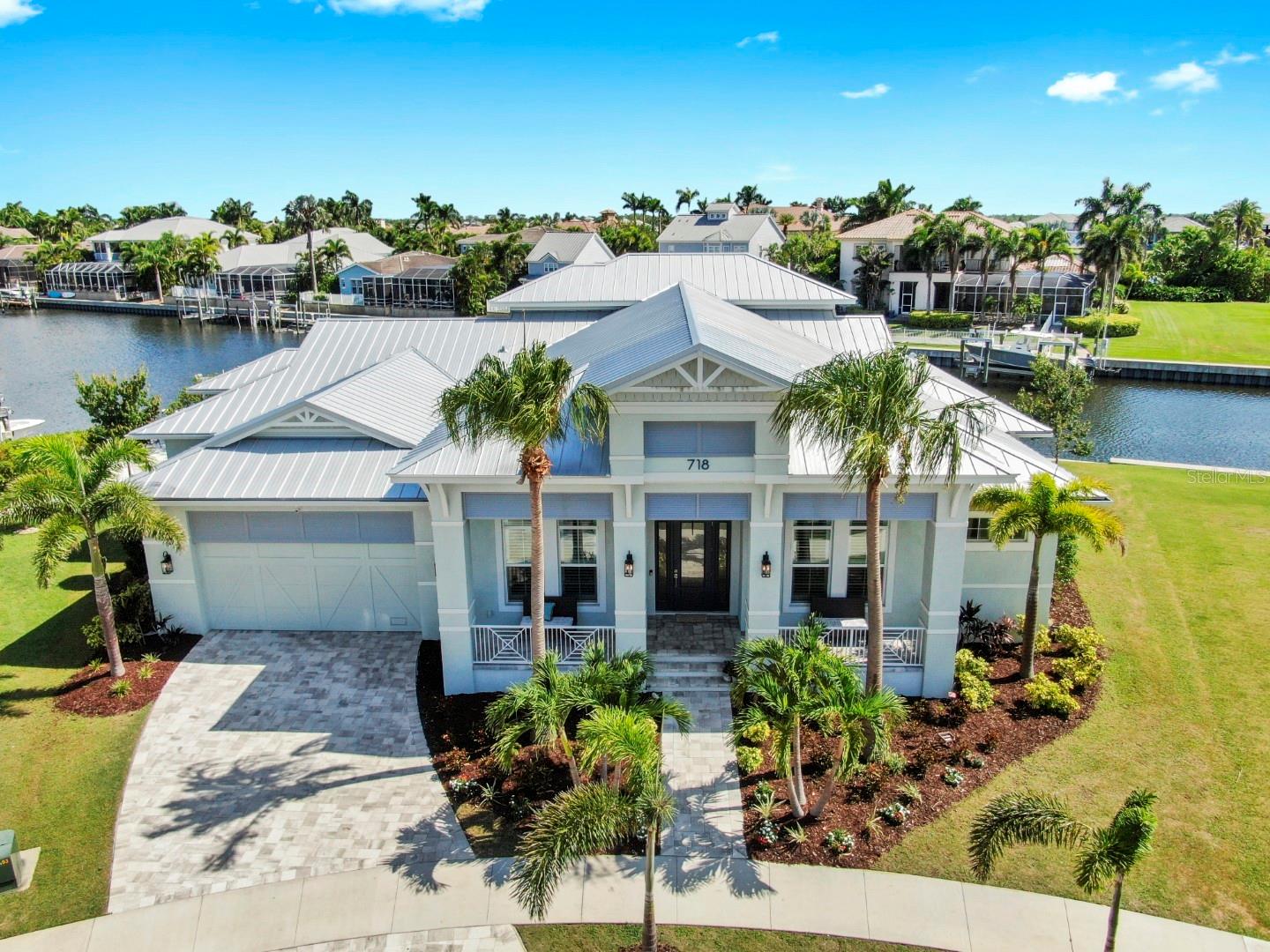 Coastal Elegance Meets Waterfront Living - Custom Luxury in MiraBay. Welcome to 718 Pinckney Drive, located in the prestigious, gated waterfront enclave of MiraBay in Apollo Beach. Built in 2021 by Alimay Homes, this 5-bedroom, 5.5-bathroom estate spans 4,355 square feet of refined living space. Located on a deep, saltwater canal with 160 ft of waterfront views and direct access to Tampa Bay, no bridges or lifts, just smooth sailing into the Gulf. From the moment you arrive, this home exudes elegance, from its wide, welcoming front porch to the custom glass entry that opens to a dramatic foyer and vaulted ceilings with exposed wood beams and detailed shiplap. Wide-plank wood flooring runs throughout both levels, no carpet in sight, adding warmth and continuity. The home features a private home office with glass double pocket doors, custom ceiling detail, and inspiring natural light. Every bedroom offers its own en-suite bath and a split floorplan with additional primary suite option, creating an elevated sense of privacy and comfort for both family and guests. The gourmet kitchen is a work of art perfectly positioned at the heart of the home with a massive island topped in 3 CM Taj Mahal Extra Leathered Quartzite, Mother-of-Pearl backsplash, JennAir appliances, a 36" induction cooktop, and a Fisher & Paykel double-drawer dishwasher. Custom coffee bar with a built-in pot filler brings café-level convenience to your morning ritual. Adjacent family room is anchored by a sleek 6-foot linear fireplace and opens effortlessly through large pocketing sliders to the oversized covered lanai. The lanai is designed for year-round enjoyment with remote-controlled privacy screens, outdoor living and dining zones, and spectacular nightly sunsets over the water. A custom outdoor kitchen, cabana, and an in-ground trampoline make this home an entertainer's dream, while Key West-style hammocks swaying by the water invite total relaxation. The luxurious owner's suite is a private sanctuary, featuring a spa-inspired bathroom with freestanding soaking tub, walk-in rain shower, dual vanities with Cambria Annicca Quartz, and a fully custom walk-in closet with its own washer and dryer. Upstairs, a spacious bonus room and a guest suite with panoramic canal views offer additional flexibility. Car lovers and anglers alike will appreciate the oversized 3-car garage with attic storage and a mini-split A/C system in the garage's custom tackle room. Peace of mind comes standard with a standing seam metal roof, impact-rated windows and doors, security cameras, and a whole-house 24kW Generac Guardian generator. For boating enthusiasts, the private dock and 16,000 lb boat lift offer effortless access to the bay, making spontaneous sunset cruises or early morning fishing trips part of everyday life. As a resident of MiraBay, you'll enjoy a lifestyle like no other: resort-style amenities including a 10,000 sq ft clubhouse, beach-entry pool with 110-foot waterslide, fitness center, tennis and pickleball courts, café, lounge, splash pad, and miles of paddle-friendly water. Social events, curated by a full-time director, create a true sense of community. Located just minutes from I-75, dining, shopping, hospitals, golf courses, Tampa International Airport, and Florida's finest beaches, this one-of-a-kind home blends luxury, location, and lifestyle into a rare waterfront offering. Schedule your private tour today and discover the ultimate in Florida coastal living!