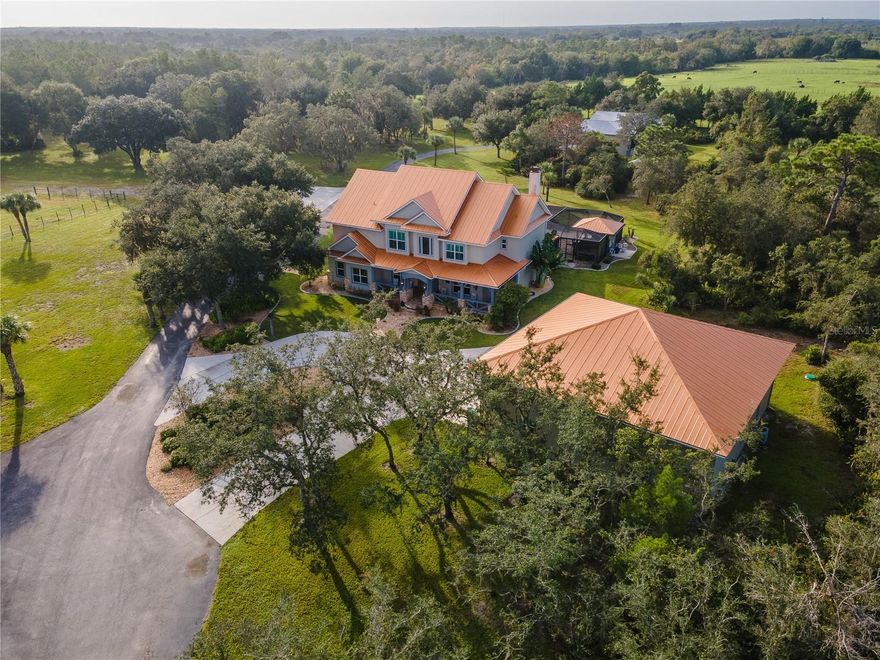 11+ ACRES! WOW! The  PRIVACY and TRANQUILITY in this one of a kind family compound is astounding. Enter through the new custom driveway gates onto the grounds of this recently UPDATED, ESTATE HOME. 5 bedrooms and 4 full baths in the +- 4000 sq ft main house plus TWO 1 bedroom guest suites -one in each of the detached buildings for a total of 7 beds 6 baths. The GREAT ROOM, with antique french doors leading to the pool/lanai area, has a 2 story STONE FIREPLACE, built-ins and room for large-family gatherings. The KITCHEN which opens into the great room, features solid wood cabinetry, stainless appliances, double oven, coffee bar, granite counters, center island, walk in pantry and breakfast room. Behind the kitchen is the ground floor PRIMARY bedroom suite with full bath, private sitting room, and exercise room. The FORMAL DINING ROOM is large enough for a table for 10. A PRIVATE OFFICE with built-ins completes the first floor. Wander up the curved WOOD stairs with elegant turned spindles and acorn newels to the landing which overlooks the 2 story entry and Great Room. The second PRIMARY bedroom suite, has a spacious elevated sitting area with LP gas fireplace, and built-ins. The second floor primary bath is a thing of beauty with custom wood cabinetry, STUNNING CUSTOM TILE WORK, granite counters, generous walk-in frameless-glass shower, large dual-sink vanity with seated make up area, WC, spa tub with custom tile surround, and 2 walk-in closets with custom built-ins. Bedroom 2 has a spectacular EN SUITE BATH, window seat and walk-in closet. Beds 3 & 4 share a Jack and Jill bath with dual sinks and seamless glass walk-in shower with custom tile work. All baths have been recently and tastefully remodeled. The Laundry Room is conveniently located on the second floor and offers a full size washer/dryer, utility sink, and tons of storage. The lanai and POOL area were completely RENOVATED with ample room for sunning or staying in the shade under the cypress ceiling, and features Brazilian hardwood deck boards, paver pool deck, HEATED SALTWATER pool with Pebble pool surface and SUN-SHELF, Pentair equipment powers the pool and spa. The covered SUMMER KITCHEN is any chefs dream, with cypress ceilings, stainless appliances, built-ins, & bar seating. Tucked in behind the kitchen is an outdoor shower. The detached garage has 2209 sq ft under AC, and features 3 RV-sized bays which could park up to 6 cars, game room loft, 1 bedroom / living room / full bath are tucked behind the garage, perfect for a caretaker. The back barn is 2608 sq ft with 2 carports, has 1 bed/bath/kitchen/laundry living quarters above, The plumbing is Manabloc with a new bloc in 2019. The main house windows, and detached garage windows are NEW with Low-E, IMPACT GLASS. 2 wells, 4 AC units, 4 septic systems. New Metal roof, soffits, gutters installed in 2023 on main home and detached garage. New four-board farm fencing, 3 automatic water troughs for livestock, and irrigation in fields around the main property. 10 minutes from I-75, 15 minutes from historic downtown Punta Gorda where you will find several choices of marinas for your BOAT, world-class restaurants, and casual shopping. Located on the Washington Loop portion of the 160 miles of bike and hiking trails, this home has it all. Outdoor adventure, privacy, yet close to activity and your everyday needs. 24 HOUR notice to show.