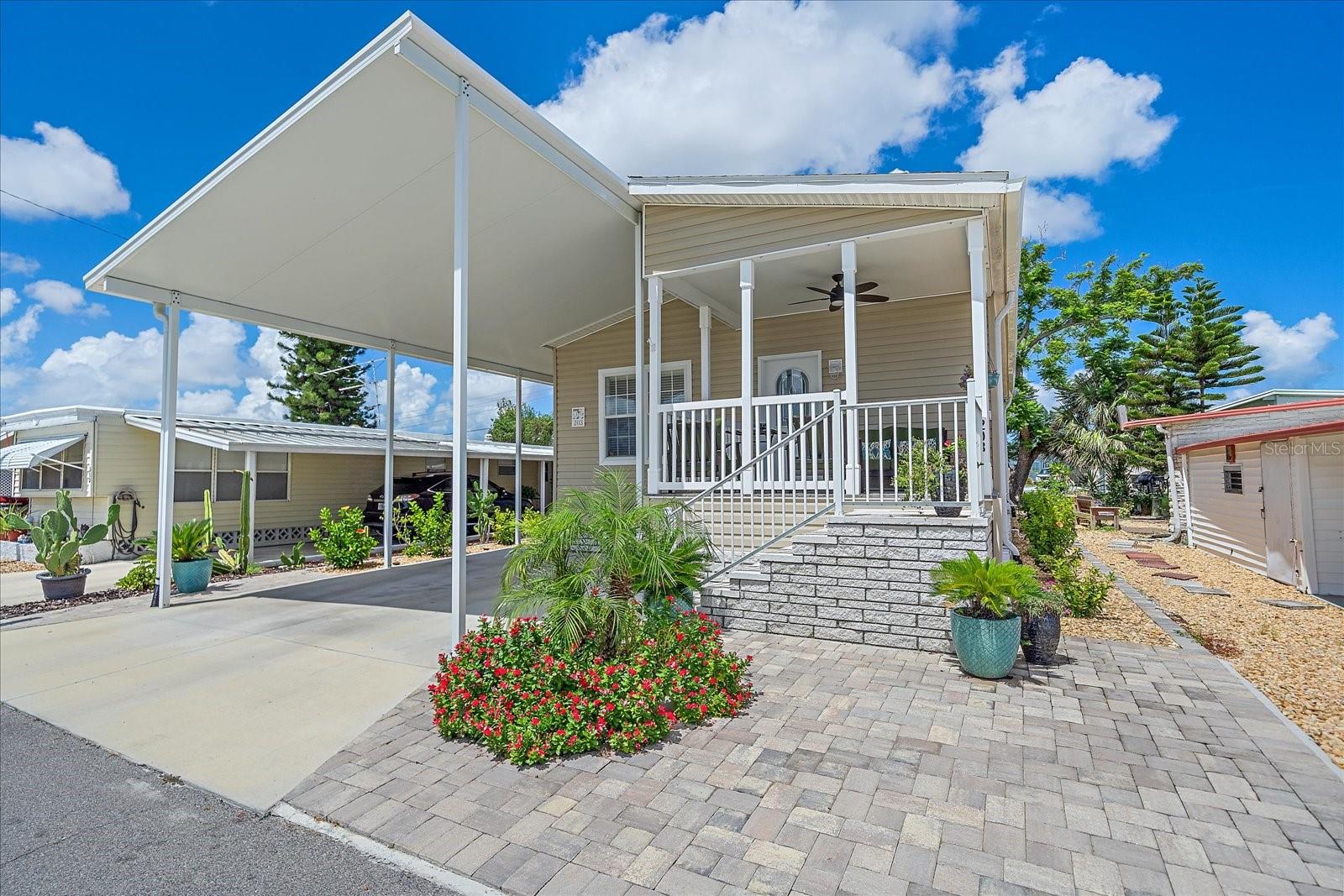 SUNSETS, WATER VIEWS & LOW-MAINTENANCE LIVING! This 2023 home in TROPIC ISLES, a 55+ RESIDENT-OWNED WATERFRONT community, offers easy Florida living. Enjoy GORGEOUS PAVER PATIOS front and back, TROPICAL LANDSCAPING. Step inside to 9’ ceilings, custom wood blinds, luxury vinyl floors, and an open-concept living and dining area. The galley kitchen shines with recessed lighting, a stainless steel FARMHOUSE SINK, and STAINLESS STEEL appliances. The spacious primary suite features water views and a beautifully upgraded ensuite with step-in shower and custom glass. MANY EXTRAS include: INDOOR LAUNDRY, attached UTILITY SHED, Ceiling fans in every room—including the front porch. Resort-style amenities include a full-service marina, heated pool, brand new fitness room, shuffleboard courts, fishing on Terra Ceia Bay, and endless community events. Annual boat slip rentals available—check with the association. Minutes to beaches, shopping, and dining. Don’t miss this gem—schedule your showing today! Click link to see a virtual tour!