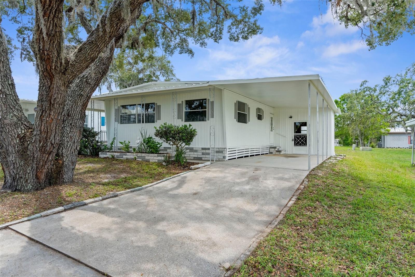 WELCOME HOME to this freshly updated and super clean home located inside the 55+ golf-community of High Point. Two bedrooms, two FULL bathrooms, with 1152 living square feet. This home offers two additional storage areas; one with a large garage door, for an additional 380 sqfeet of storage space. The kitchen has been entirely remodeled with new cabinets, new counters, and all new stainless steel appliances including a gas range/oven. Nice eat-in space off the kitchen. Large living room. Freshly painted exterior. Both bathrooms come with tiled showers. Exterior covered porch and exterior enclosed porch offers additional space to enjoy your home whilst avoiding any inclimate weather. BRAND NEW HVAC (06/2025). Metal roof. Covered, one-car carport and long driveway. HOA dues are $45/month. The High Point 55+ Community offers amenities such as Golf, tennis, pickleball, shuffleboard, heated pool, social events and so much more. Close to shopping, restaurants, entertainment, and medical facilities.