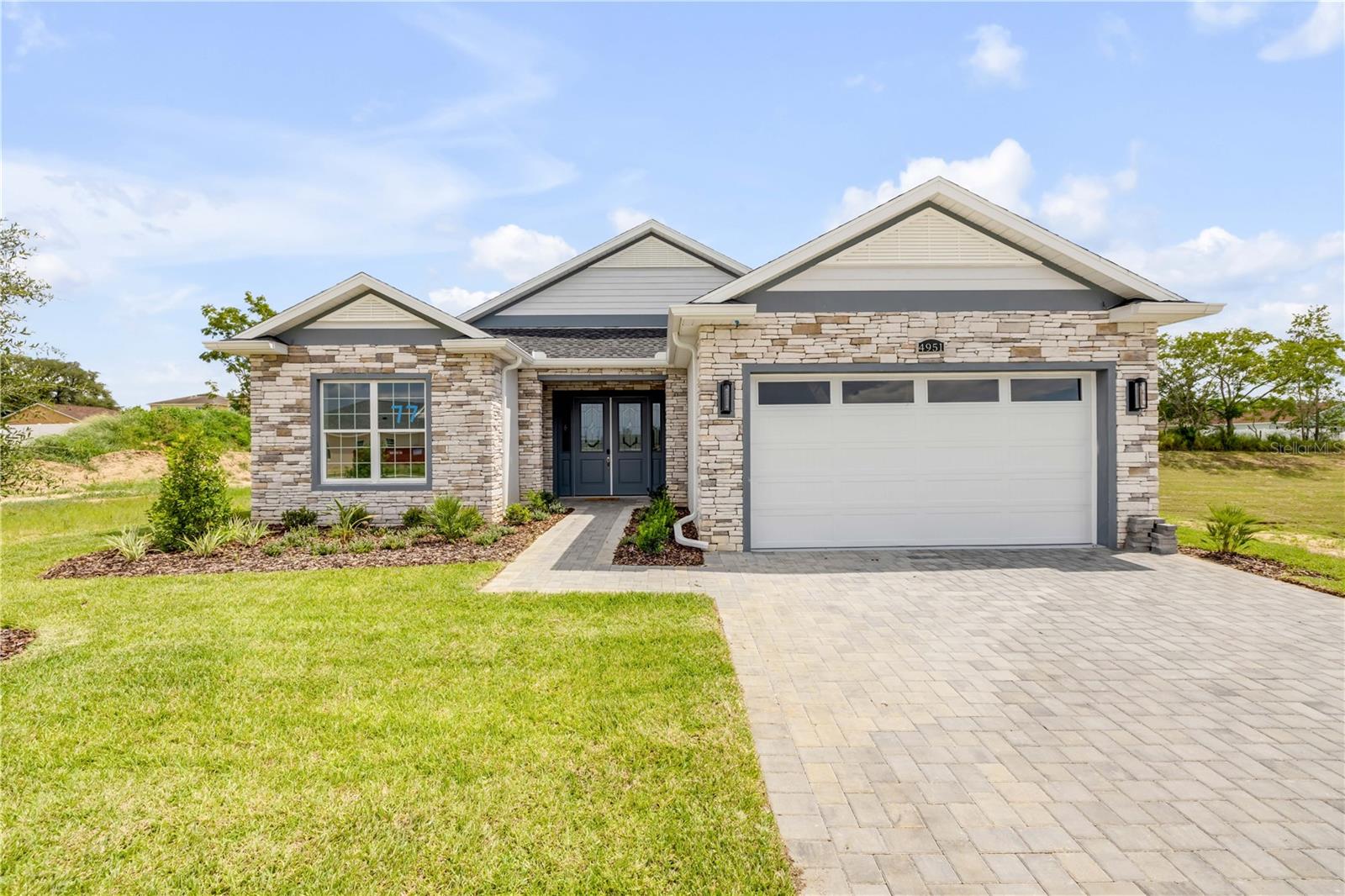 Experience BRAND NEW LIVING in the heart of the Central Villages area! This stunning 3-bedroom, 2-bath home in the desirable all-ages community of Densan Park offers exceptional style and convenience just next door to THE VILLAGES. This exceptional residence blends refined design with resort-style living. A paver driveway, covered entry, and welcoming foyer set the tone for elegance. Inside, the open-concept layout is enhanced by soaring 10-foot walls, vaulted ceilings, crown molding, and 8” x 47” wood-look porcelain tile throughout. The chef’s kitchen features premium stainless steel appliances, sleek quartz countertops, and comes complete with a refrigerator, washer, and dryer. Step outside to the covered lanai and your fully equipped summer kitchen—featuring a sink, cabinetry, grill, range hood, and refrigerator—perfect for elevated entertaining. The primary suite is a private retreat with a tray ceiling, spa-inspired ensuite bath, and walk-in closet. With no neighbors behind and none on one side, you’ll enjoy privacy and serene surroundings. DENSAN PARK offers exclusive amenities—Tennis Courts, Full-Court Basketball, Volleyball, a Fitness Trail with Exercise Stations, Dog Park, and Covered Picnic Areas—all just minutes from The Villages’ shopping, dining, and entertainment, and LESS THAN 2 MILES FROM THE VILLAGES CHARTER SCHOOLS. Luxury, leisure, and location—this home has it all.