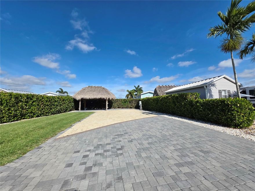 LOCATION, LOCATION, LOCATION! Motivated Seller! 
This is not just an RV pad—it's a fully developed tropical retreat. With full pavers, lush mature privacy 
landscaping, a beautifully built tiki hut, and prime placement across from the newer bathhouse with the 
easiest in and out of any lot! This property stands out as one of the most desirable lots in the resort.
Lot Features include: Full paver driveway in pristine condition lined by large river rocks making for easy maintenance. 
Mature beautiful Clusia trees with a built-in soaker line, surrounding the entire lot, creating a lush, 
private tropical barrier. 
• Expansive tiki hut featuring: wood beam construction, modern ceiling fan, mounted outdoor TV and power outlets throughout the Tiki for convenience. 
• Beautiful green lawn maintained by a full sprinkler/irrigation system 
• Meticulously serviced year-round, including pest treatment 
• Power, water and sewer stubbed for a casita 
• Easy pull-in/pull-out design, perfect for any size RV, fifth wheel, or Class A 
• Peaceful location with friendly neighbors and wide open green-space views