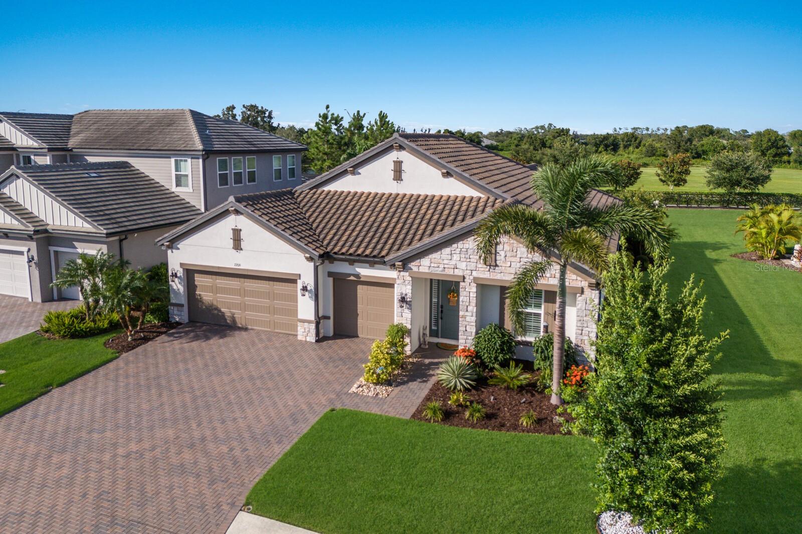 Beautifully upgraded and meticulously maintained, this British West Indies Crystal floor plan residence looks and feels like a model home. This impressive residence features three bedrooms plus a den, three bathrooms, and a three-car garage, providing an exceptional blend of elegance and comfort. The well-designed open floor plan presents a modern and functional layout, grounded by engineered hardwood floors, flooding the expansive living room and kitchen combination with an abundance of natural light. The chef’s kitchen is a gourmet delight, where you’ll find a sizable center island with a farmhouse sink, GE Profile Stainless steel appliances, a gas cooktop, a French door Samsung refrigerator, painted wood cabinets, and quartz countertops. The pantry has custom built-in storage. The open family room is stunning, with a wood-beamed tray ceiling. Living and kitchen areas have a seamless indoor-outdoor flow through five large sliding glass doors leading to the fully screened, oversized lanai. The lanai is surrounded by an exquisite backyard oasis, with an expansive paver brick patio and several seating areas, including an outdoor fire pit area. The den has custom-designed barn doors and a built-in dry bar. The owner's retreat is a sanctuary of comfort, offering a spacious walk-in closet with custom built-ins, and an en-suite bath with dual sink vanities, expansive countertops, a generously sized walk-in shower, AND a soaking tub. The guest suites are generously sized, with custom built-in closets. One guest suite also has a built-in desk area in addition to the large custom closet. Interior doors are 9 ft, adding to the open, light-filled ambiance. Even the garage entry and laundry room are special, where you’ll find a generous drop zone, custom cabinetry, and another farmhouse sink. Woodleaf Hammock, a sought after gated community in Lakewood Ranch, features resort-style amenities including a community pool, lounging areas, playground, pickleball courts, and a dog park. This property is centrally located close to Lakewood Ranch Blvd, between SR 70 and SR64, offering easy access to shopping, restaurants, I75, and excellent schools, making it a convenient and well-connected home.
