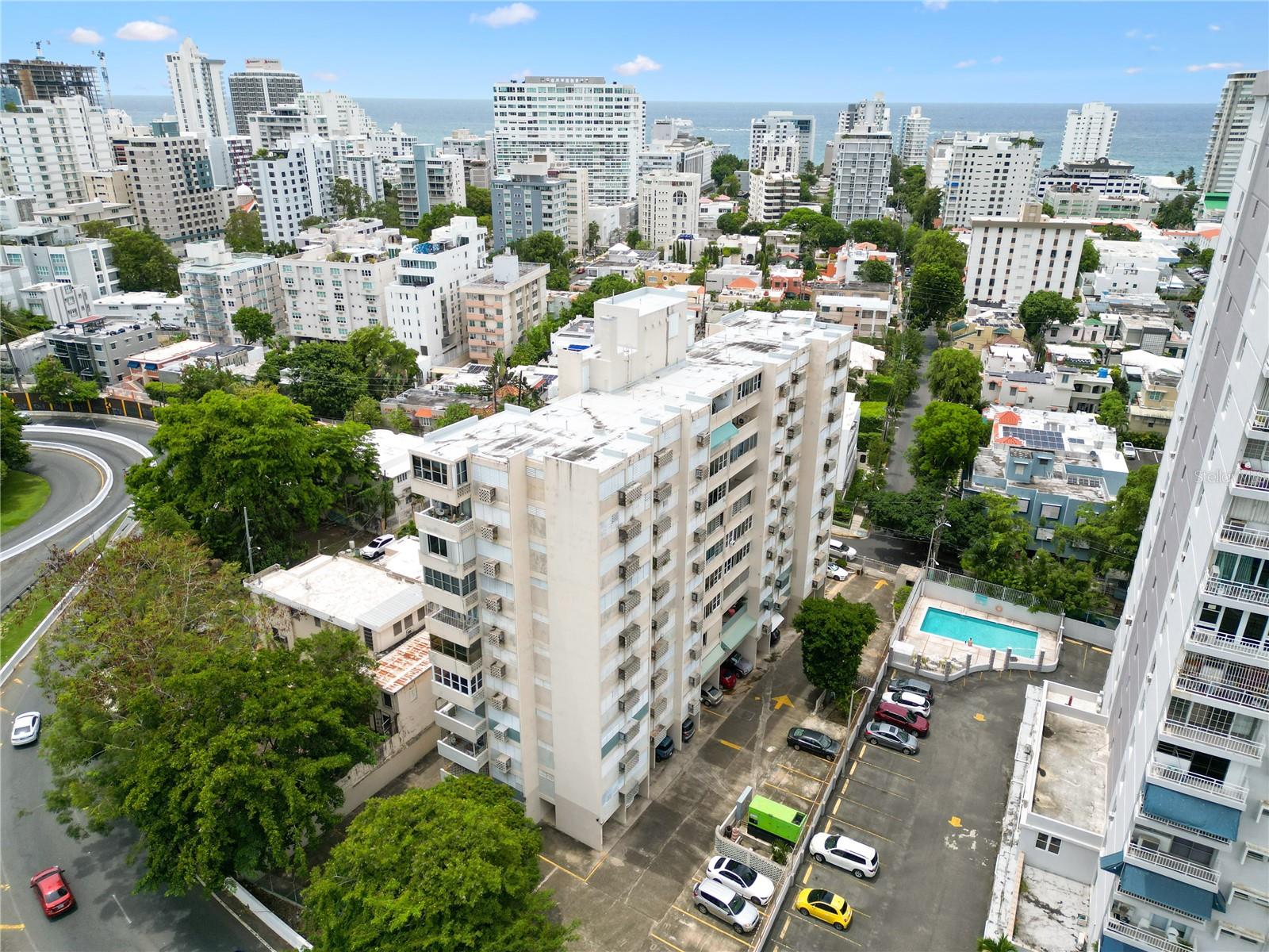One or more photo(s) has been virtually staged. Tucked into the quieter, southern stretch of Condado’s Washington Street—where the rhythm slows just enough to allow reprieve from the thrum of oceanfront glamour—is a rare find: a fully remodeled three-bedroom, two-bath apartment that strikes a balance between urban convenience and modern design within a classic mid-century shell. Built in 1962, the building is part of Condado’s original wave of vertical living—an era marked by subtle elegance and clean lines—and this unit brings that legacy forward with a contemporary twist. Gutted to the studs and reimagined with wide-format matte porcelain tile flooring, sleek white cabinetry, polished neutral-toned quartz countertops, and full glass stackable balcony doors, the apartment feels airy, bright, and quietly sophisticated. The finishes are trendy yet understated, allowing a future owner to channel the spirit of mid-century modern with furnishings that echo the building’s roots.
What truly elevates this unit beyond the aesthetics, however, is its livability. The building itself may be modest in stature and without lavish amenities, but it surprises where it counts: a full power generator and a water cistern serving the entire structure—rare commodities in this price range that transform daily living from uncertain to seamless. A covered parking space just steps from the entrance (a thoughtful touch when the tropical skies open up) and the unit’s position on a tranquil street with easy ingress and egress round out a lifestyle of low-stress city living. It’s that rare Condado blend of privacy, practicality, and design-forward charm, shielded from the density of the hotel corridor yet effortlessly walkable to cafés, grocery stores, and the area’s most essential destinations.
At $475,000, it’s a compelling proposition. Inventory for three-bedroom apartments in Condado with parking, full backup power, and contemporary upgrades is virtually nonexistent below the half-million-dollar mark. This residence—arguably the most attractive unit in its building—delivers exactly that: a fully renovated, move-in-ready space that honors its mid-century bones while offering all the modern essentials for an elevated urban lifestyle. On a street known for its name more than its noise, this is where design meets discretion.