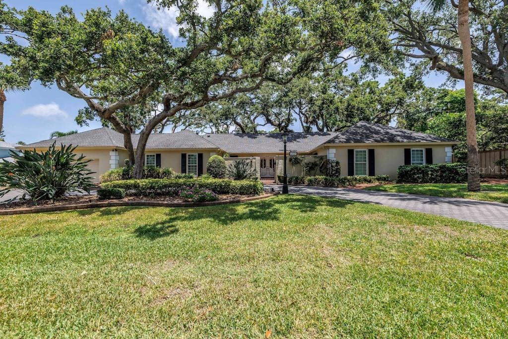 Offered for the very first time by its original owners, this enchanting 4-bedroom, 3.5-bath, 2-car garage pool home spans nearly 3,300 sq ft and draws inspiration from the timeless charm and elegance of New Orleans’ Garden District. A rare blend of sophistication and warmth, this residence is a true architectural treasure in one of St. Petersburg’s most storied and beloved neighborhoods. Enter through wrought iron gates into a brick-paved courtyard that sets the stage for what lies beyond. The dramatic 29-foot foyer welcomes you with grandeur and opens seamlessly into the formal living and dining rooms. Four sets of French doors lead to the expansive 17’ x 33’ courtyard, complete with a classic gurgling fountain – the perfect backdrop for al fresco dining or evening entertaining under the stars. The generously sized family room invites relaxation, featuring a built-in bookcase and wet bar ideal for hosting. The efficient kitchen includes a cozy eat-in area, while the adjoining den – often used as a music room – is finished with timeless tile flooring and a powder room that’s truly a “jewel box.”
Out back, the party-sized pool (16’ x 33’) is accompanied by a full bath – perfect for poolside guests. Meander along the oak-shaded walkways and wooden decks that wind through the backyard, offering a touch of magic and serenity. All four bedrooms are situated on one side of the home, including a primary suite that impresses with a glamorous ensuite and private entry via a long, closet-lined hallway.
Set in the much sought-after neighborhood of Jungle Prada, you’ll enjoy easy access to waterfront parks, a boat launch, and a scenic fishing and observation pier overlooking Boca Ciega Bay — all just a short stroll away. What a fabulous opportunity to experience the mystery
and character of this extraordinary area and make it your dream come true. Items to Note: hurricane impact windows. This is more than a home – it’s a lifestyle, steeped in grace, history, and enduring character. Let the magic of this French Chateau sweep you off your feet.