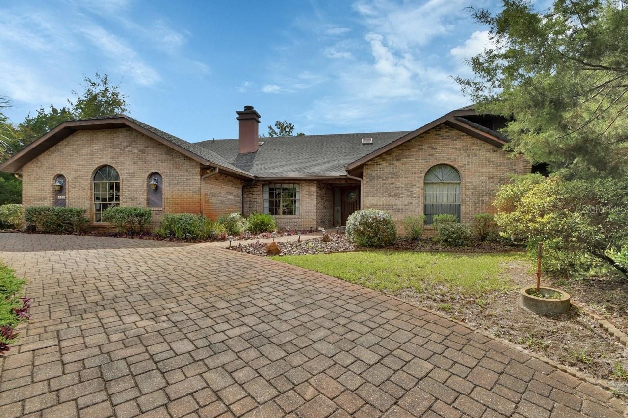 One-of-a-Kind Custom Brick POOL Home in the highly sought after estate area of Trails West in North DeLand!
Welcome to this exceptional traditional brick POOL home, custom-built with timeless design and unmatched quality. Perfectly situated on a generous 0.69-acre estate lot in the highly sought-after Trails West community, this residence offers the ideal combination of space, comfort, and elegance — with approximately 2,800 sq. ft. of living space.
Thoughtful Floor Plan & Timeless Design
As you step through the covered entry, you are welcomed into a spacious foyer that opens into formal living and dining areas, highlighted by hardwood trim and finishes. The formal living room has large sliding glass doors that seamlessly open to the screened-in pool area, creating a perfect indoor-outdoor flow.
The split-bedroom layout offers ultimate privacy, with the primary suite and second bedroom located on one side — making the second room ideal as a nursery, office, or studio. A hallway closet and half-bath serve this side of the home conveniently.
Open Living Spaces
The heart of the home features a galley-style kitchen, great room, and cozy dinette area — all overlooking the private backyard and sparkling pool. The floor-to-ceiling wood-burning fireplace in the great room creates a warm and inviting atmosphere, perfect for gatherings.
Off the dinette, you'll find two spacious guest bedrooms and a full pool bath, providing privacy and comfort for family or guests.
The private primary suite is your personal sanctuary, featuring sliding glass doors to the pool, an expansive ensuite bathroom with dual vanities, garden tub, oversized walk-in shower, private water closet, including a large walk-in and an additional linen closet.
Ceramic tile throughout most of the home (carpet in bedrooms 3 & 4). Beautiful solid hardwood doors, trim, and framing.
Oversized utility/laundry room with abundant cabinetry, a built-in closet, countertop workspace, and a soaker tub. The Side-entry garage has pull-down attic access and floored storage space.
Elegant paver-accented circular drive at the main entrance. Outdoor Living at Its Best. Relax or entertain in the screen-enclosed pool area with cedar ceiling, covered patio, and a pass-through window from the kitchen. There's even a space for a future summer kitchen. A separate built-in storage room at the back of the home provides additional space for lawn equipment, a workshop, or gardening tools.
This home is more than just a place to live — it's a lifestyle. With a perfect blend of traditional charm, smart design, and outdoor living, this Trails West gem is truly one of a kind.