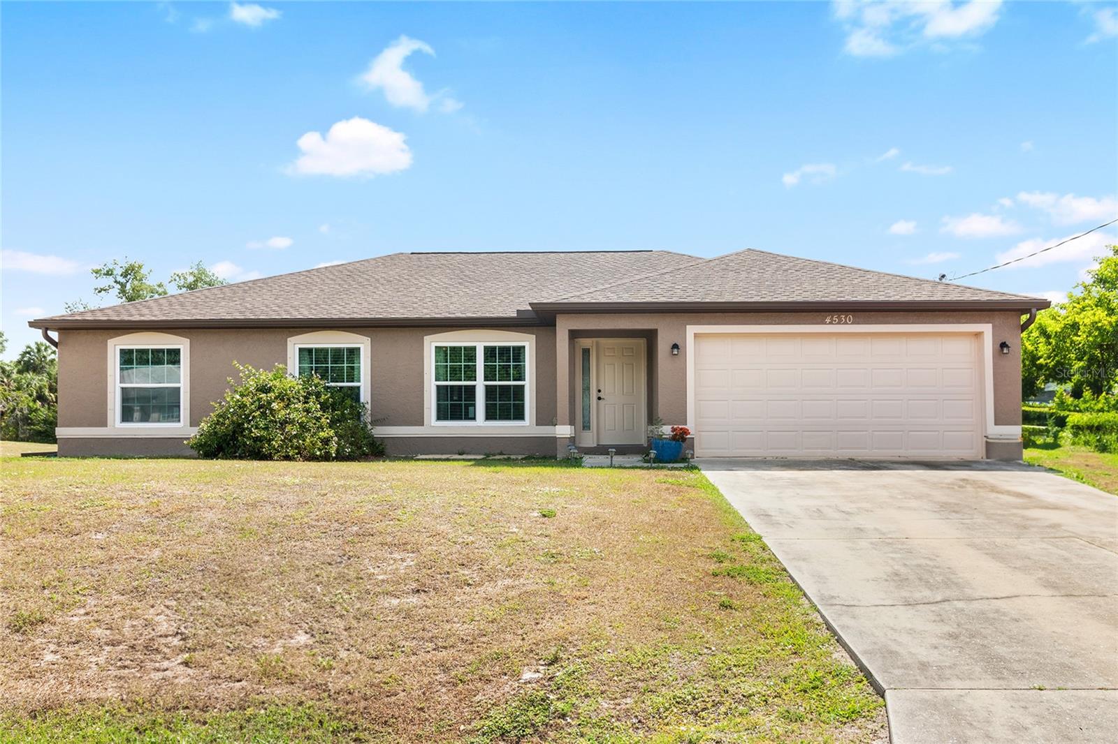 Welcome to your future home! Nestled on a peaceful street just minutes from shopping and dining, this charming residence offers a blend of modern updates and inviting spaces. Enjoy peace of mind with a recently installed 2023 roof and new gutters at both the front and rear and a 2019 A/C. The fully fenced backyard, secured with a vinyl privacy fence, provides a private outdoor retreat. Inside, the home features tile flooring throughout, a generous living room, and well-sized bedrooms. The master suite is a true highlight, offering a large walk-in closet, a walk-in shower, and a luxurious soaking tub. The open floor plan enhances the spacious feel, with a huge living room and a kitchen equipped with stainless steel appliances and a convenient bar area. Additionally, the large rear lanai is perfect for outdoor entertaining or relaxing. Designed for comfort and functionality, this home is an ideal choice for anyone seeking a peaceful yet convenient location. Don’t miss out—schedule your visit today and discover all that this wonderful property has to offer!