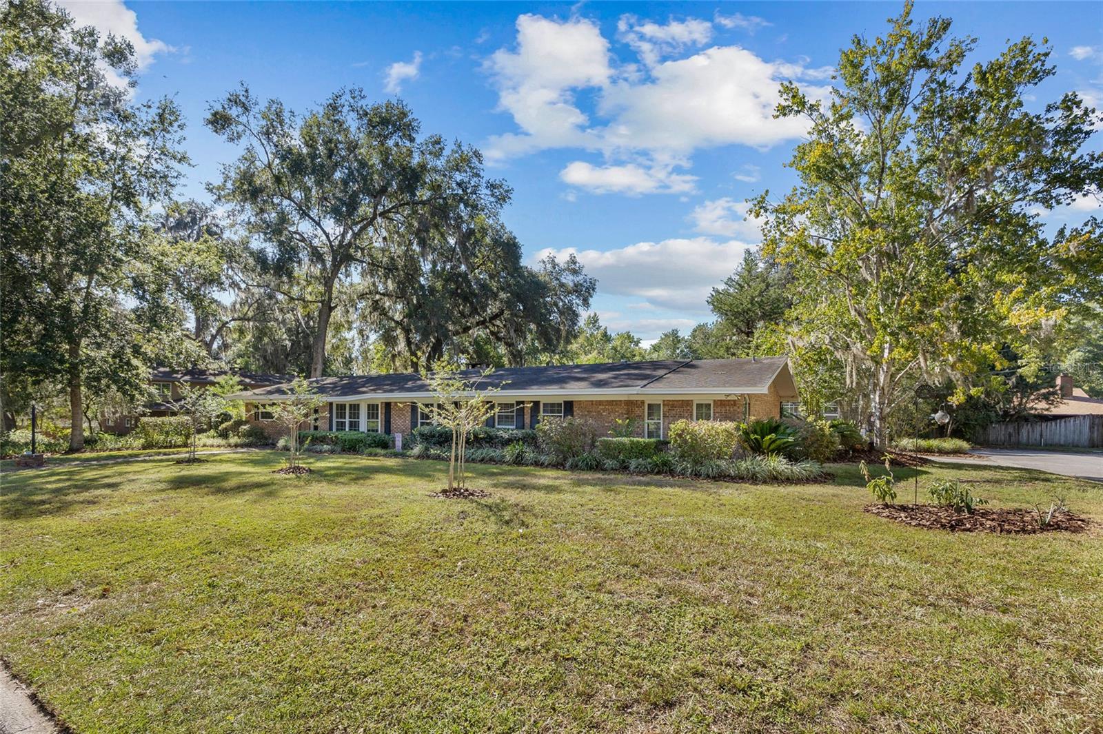 Tucked away on a quiet dead-end street in a peaceful neighborhood, this stunning 5-bedroom, 4-bath brick home offers the perfect blend of space, privacy, and convenience—just 2 miles from the University of Florida! Step inside to more than 3,000 sq. ft. of light-filled living space, highlighted by vaulted ceilings and multiple skylights. The large master suite is a retreat of its own, featuring a spa-inspired bathroom with quartz countertops, double sinks, a soaking tub, oversized walk-in shower, and an expansive closet. All bedrooms and closets are generously sized, with the fifth bedroom offering private access—ideal for a mother-in-law suite, guest quarters, or rental opportunity.
The kitchen boasts custom wood cabinetry, stainless steel appliances, and a window overlooking the home’s show-stopping sunroom. With stained-glass accents, exposed beams, a mini-split system, and panoramic windows framing the backyard, the sunroom provides the perfect year-round gathering space. A gorgeous brick wood-burning fireplace. Out back, enjoy Florida living on the expansive patio or relax in the screened-in pool and hot tub, with recent upgrades including a new $10k pool pump. The private, fenced yard is perfect for enjoying Florida living at its finest. The two-car garage features a side workshop area, ideal for hobbies or storage. Additional updates include $15k in electrical improvements for peace of mind. No HOA. IQ Fiber high internet service. Just minutes from scenic trails, county schools, Santa Fe College, UF/Shands, the VA, and HCA Hospital. This home combines character, updates, and an unbeatable location in a family-friendly neighborhood with welcoming neighbors. Truly a rare find so close to UF!