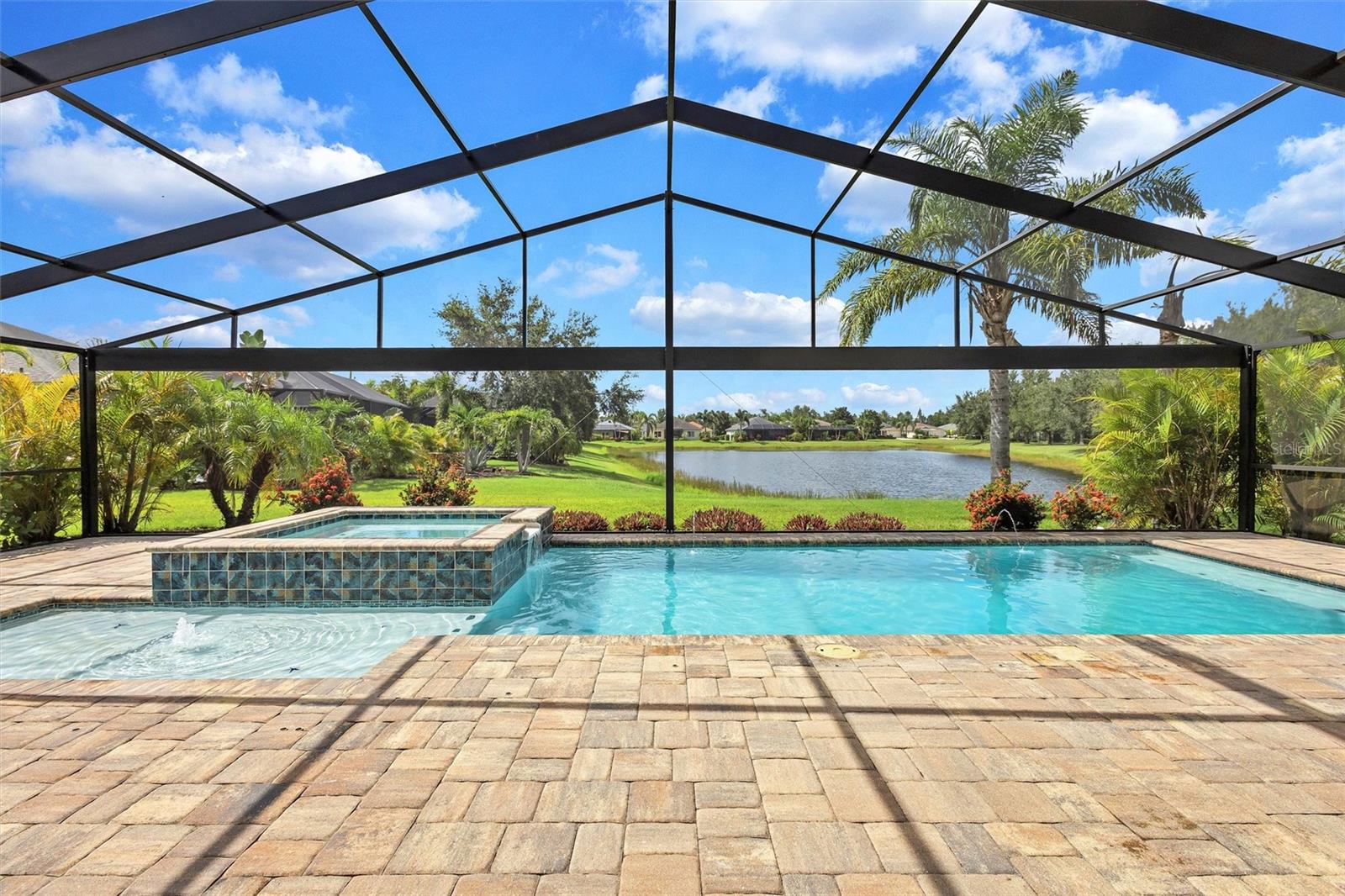 Welcome to your Dream Home, a delightful haven nestled in the vibrant heart of Lakewood Ranch. This well maintained four-bedroom, three-full bath, three car garage home, complete with an expansive bonus room on the upper level, harmoniously blends comfort, convenience, and exceptional Florida living within the desirable coveted neighborhood of Central Park. The home is set on a generous 0.25-acre premium waterfront lot, which includes a peaceful backyard oasis with lush mature landscaping. This property offers an oversized enclosed lanai complete with brick pavers and a magnificent panoramic screen allowing unobstructed views of the serene pond while swimming in the gorgeous heated salt-water pool and jetted spa, perfect for relaxation and entertaining. Step inside the double doors with transom window to a bright, welcoming atmosphere that immediately feels like home. This Kingfisher II by Cardel Homes boasts quality, soaring ceilings, and an open floor plan that connects the gourmet kitchen, spacious great room and dining area to create a central living space where memories are made. Whether hosting Holidays, Parties or hanging with friends and family, this layout encourages connection. The nicely appointed Kitchen is a chef's dream with a GE Cafe' Gas Range and GE stainless steel appliances, solid wood-soft close cabinets, quartz countertops, breakfast bar, built-in desk, island and a walk-in pantry for ample storage. Designed for both everyday meals and entertaining, this space balances beauty and function. The sliding glass doors and transom windows are the focal point in the Great Room which seamlessly connect the picturesque outdoors. Adorned with French Glass doors, the private study/den offers a quiet retreat for remote work, reading or hobbies. It contains a walk-in closet which can also serve as a fourth bedroom. Whatever you choose, this flexible room can be tailored to your needs. The owners suite is privately situated on the first floor and is the perfect place to relax and unwind with tranquil pond views through the sliding glass doors that lead out to the lanai. It boasts a huge walk-in closet, garden soaking tub, dual sinks with granite countertops, rejuvenating walk-in tiled shower and separate water closet. The additional guest bedrooms are located on the opposite side of the house allowing privacy when needed and conveniently share a full bath with direct access to the pool area. NOTABLE HIGHLIGHTS of this home include a whole house softening filtration system with reverse osmosis, BRAND NEW ROOF just completed 6/2025 which provides peace of mind, rain gutters, hurricane shutters for windows and doors and the gorgeous POOL with LED Lighting and ENCLOSED SCREENED LANAI is ONLY 3 YEARS OLD! Central Park HOA Fees are LOW and community amenities include a 10-acre park for all to enjoy including 2 dog parks, tennis courts, ball field, kid's adventure park, splash pad, covered pavilion, meandering trails, and monthly social events. Your family will appreciate the close proximity to the districted top-rated A+schools that you can walk to or ride your bike. Ideally located near shopping and dining, with easy access to Sarasota, St. Petersburg, Tampa and the renowned white sandy beaches of the Gulf of Mexico, this home truly has it ALL, is priced to sell and ready for its new family! This amazing Florida lifestyle awaits you so schedule your showing today and see for yourself why Central Park is so wonderfully adored.