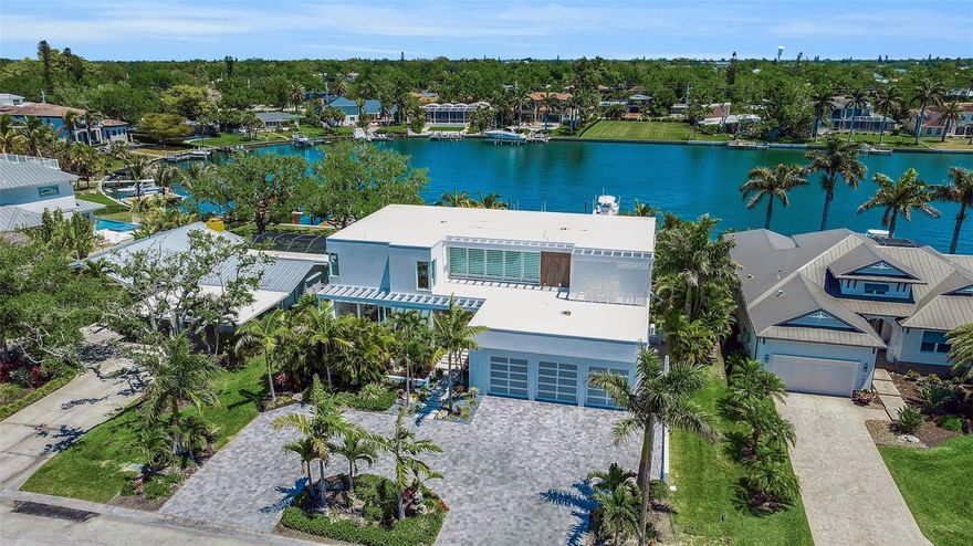Anchored in one of Sarasota’s most coveted deep water waterfront communities, 3631 San Remo Terrace presents a rare opportunity to own a modern luxury home with direct boating access in San Remo Estates, just moments from Siesta Key, Downtown Sarasota, and Southside Village. Completed in 2021 by award-winning designer Stephen Chung and enhanced with thoughtful 2025 upgrades, this coastal contemporary residence blends clean architectural lines with warm, natural finishes, ideal for buyers seeking newer construction, move-in-ready condition, and hurricane-resilient design in a prime location. Positioned on protected sailboat water with no fixed bridges, the property offers seamless access to Sarasota Bay and a short, unobstructed ride to the Gulf, making it perfectly suited for avid boaters. Spanning approximately 4,750 square feet under air, with nearly 3,000 additional square feet of outdoor living space, the home is designed around the indoor-outdoor lifestyle today’s luxury buyers prioritize. The open-concept layout is anchored by a chef’s kitchen featuring a sculptural marble island and Sub-Zero and Wolf appliances, flowing effortlessly into a great light-filled room with a stone fireplace, custom built-ins, and floor-to-ceiling glass sliders that open to expansive terraces. A temperature-controlled wine room with 1,800-bottle capacity adds a refined touch, while the dining space creates a striking architectural focal point. The primary suite offers true resort-style living, with private access to both a tranquil courtyard with spa and sauna and the waterfront pool terrace. Inside, a custom walk-in closet and spa-inspired bath reflect the level of finish expected in a luxury retreat. The second level features three additional bedrooms, a flexible gym or office, and a loft-style workspace, providing versatility for modern living. Outdoors, the illuminated saltwater pool with a glass wall, newly enhanced outdoor kitchen, and expansive entertaining areas create a private waterfront oasis. The deep-water dock is equipped with a 20,000-pound boat lift, dual jet ski lifts, and a floating dock, delivering a true boating lifestyle. Additional highlights include a three-car garage with a lift, epoxy flooring, and custom storage. A fully integrated smart home system, featuring programmable lighting and shades, whole-home audio, Apple TV integration, a generator, and high-speed WiFi, meets the expectations of today’s tech-forward buyer. Furniture is available separately to create a more turnkey concept. Located within San Remo Estates, the home offers a rare balance of privacy and central convenience. Just minutes from Siesta Key via the nearby North Bridge, beach access becomes part of everyday life. Set on a deep-water basin seconds from Sarasota Bay, the property provides protected docking with immediate access to open water and a short ride to the Gulf. Southside Village and Downtown Sarasota are both a quick drive away without the need to cross any bridges, offering boutique shopping, cafés, acclaimed dining, and a vibrant arts and cultural scene. Everyday conveniences, including top-rated schools, Sarasota Memorial Hospital, and key corridors like US-41 and I-75, are all within close reach. This is a location that seamlessly connects protected waterfront living with the very best of Sarasota.