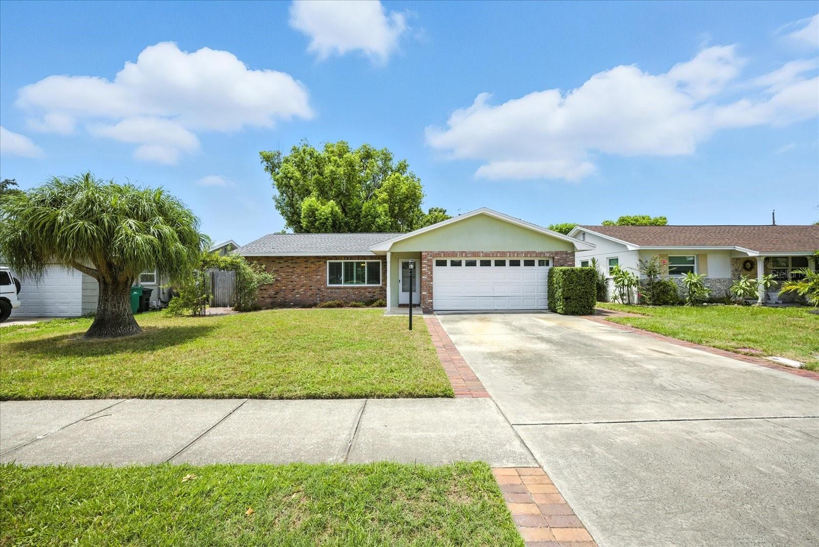 ENDLESS POTENTIAL. This well-maintained block home features a 2024 roof, impact-rated windows and slider, 2019 A/C, 2016 water heater, and freshly polished terrazzo floors, offering peace of mind on the major systems. Enjoy quick access to Gulf beaches, top-rated schools, shopping, and dining. The layout includes two bedrooms, two full baths, and two spacious living areas surrounding a centrally located kitchen. The primary suite and guest bedroom offer comfortable square footage and natural light. A fenced backyard creates a private outdoor retreat, a nature lovers dream, while the two-car garage adds storage and flexibility. Set in a non-flood, non-evacuation zone with sidewalks and a welcoming neighborhood feel, this home offers comfort, convenience, and the opportunity to make it your own.