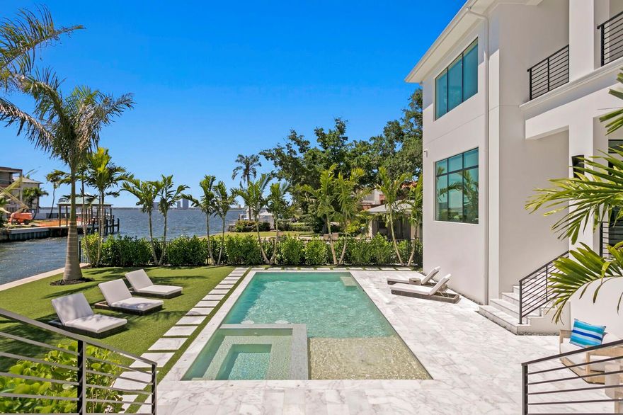 Davis Islands Unrivaled Luxury. Coastal Modern 2023 built waterfront construction boasting spectacular views and breathtaking sunsets on one of the neighborhood’s most sought-after streets. Extensively upgraded by the current owners after initial construction, enjoy the perfect slice of paradise throughout this waterfront masterpiece with superior craftsmanship, open bay views and deep-water dock on over 100 ft of water frontage. Built to the latest building codes with concrete block construction, impact windows/doors, and elevated FEMA-compliant living for flood risk reduction and optimal insurance premiums. From the impressive pivot glass door entry, you’re greeted by a two-story grand foyer, glass walls and expansive light filled living spaces. With refined finishes, stunning hardwood floors and designer lighting throughout plus full retracting glass doors from the great room to the covered terrace beyond. Offering a sleek dual island chef’s kitchen with Wolf/Sub-Zero appliances, Miele coffee station and adjacent catering kitchen, and water view dining and glass enclosed wine room. The first level also offers an ensuite guest room, an additional waterfront guest suite and one of two laundry rooms. Your choice of a convenient 3-stop elevator or sleek stairway lead to the second level featuring an elegant primary retreat with full morning bar, custom his and her closets, tray ceiling, expansive water views and a private terrace. The luxurious bath boasts a deep soaking tub and generous glass shower with dual shower heads. The second level includes 3 additional ensuite guest rooms, an expansive media/bonus room with entertaining wet bar and private bath, along with a second laundry room. The very best of Florida waterfront living awaits outdoors with the designer saltwater pool and spa, elegant marble pool deck and generous covered terrace for entertaining with a gas fireplace, full outdoor kitchen, waterfall-edge island, plus large living and dining areas overlooking the water. A 3 Car garage with recent buildout can also accommodate future lifts for car additional storage. Minutes to the Open Bay, the yacht-ready full-service dock, along with power/water and lighting for the best of boating any time of day or night. Additional upgrades by current owner include a whole home generator, smart home technology, advanced AV and blinds system, upgraded door package and designer lighting throughout, dock upgrades plus an extensive mature tropical landscape and landscape lighting system package. The envied Davis Islands lifestyle provides a vast array of recreation both on and off the water. Residents enjoy a yacht club, private airport, tennis complex, community pools, Davis Islands Beach, parks and more. Offering A-rated schools and convenience to endless recreation, Water Street and Riverwalk, sports venues, shopping, dining and entertainment, come home to Ultra Luxury and the epitome of exceptional Waterfront Living in the heart of South Tampa. Note: Owner invested in significant upgrades and enhancements since purchase.
