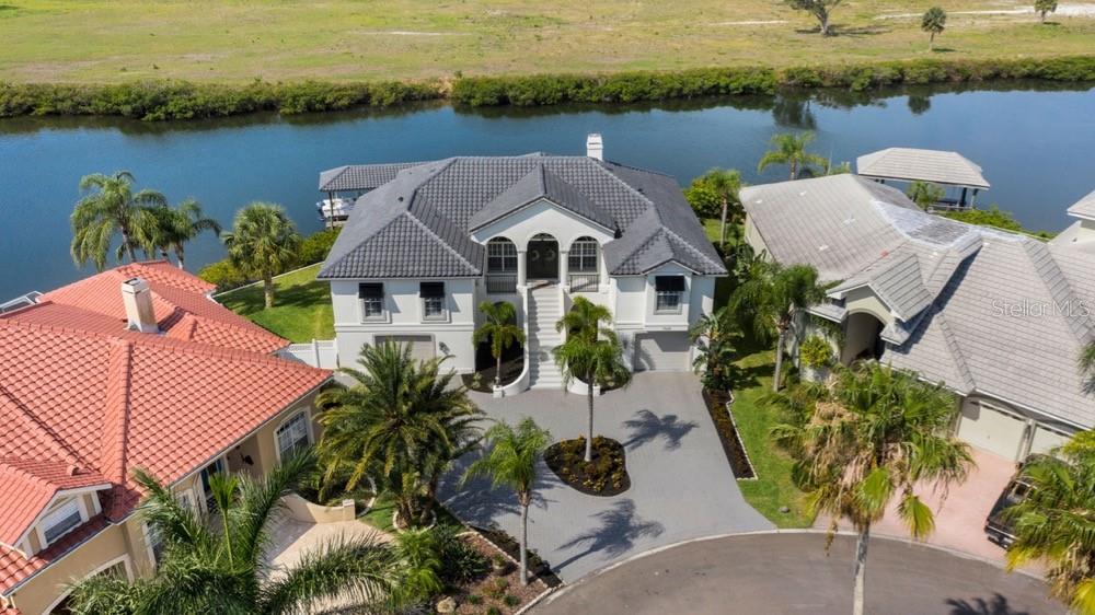GORGEOUS WATERFRONT in exclusive Symphony Isles gated community. Enjoy 140 ft of water shoreline with spectacular sunrises, sunsets, and Saint Petersburg city skyline views from this beautiful home sitting at the end of the cul-de-sac. This coastal paradise was recently renovated with an open concept living overlooking Tampa Bay, walkway to a new covered dock including electric & water, 12K lb. lift, and built to accommodate up to a 35-foot boat. The main living floor plan is 2911 sq ft with a spacious living and dining room with 13 ft ceilings, 4 bedrooms, and 3 bathrooms. The garage is 2900 sq ft with a half bath, can hold up to 6 cars, storage racks, and large driveway. This property has a heated saltwater pool with breathtaking panoramic views (enjoy manatees, dolphins, and sting ray sightings), Plantation Shutters inside and Bahama Shutters outside, Hunter Douglas electric blackout shades on all of the Hurricane Sliders inside, travertine flooring throughout, just installed BRAND NEW tile roof, new A/C, water softener, two new hot water tanks, deep well for affordable lawn irrigation, security system, and a gas fireplace.
Symphony Isles community has NO CDD, Low HOA $155.00 monthly which includes: 24x7 guard, community pool, playground, private beach and picnic area with volleyball, private boat ramp for Symphony Isles residents, and so much more! See it today!