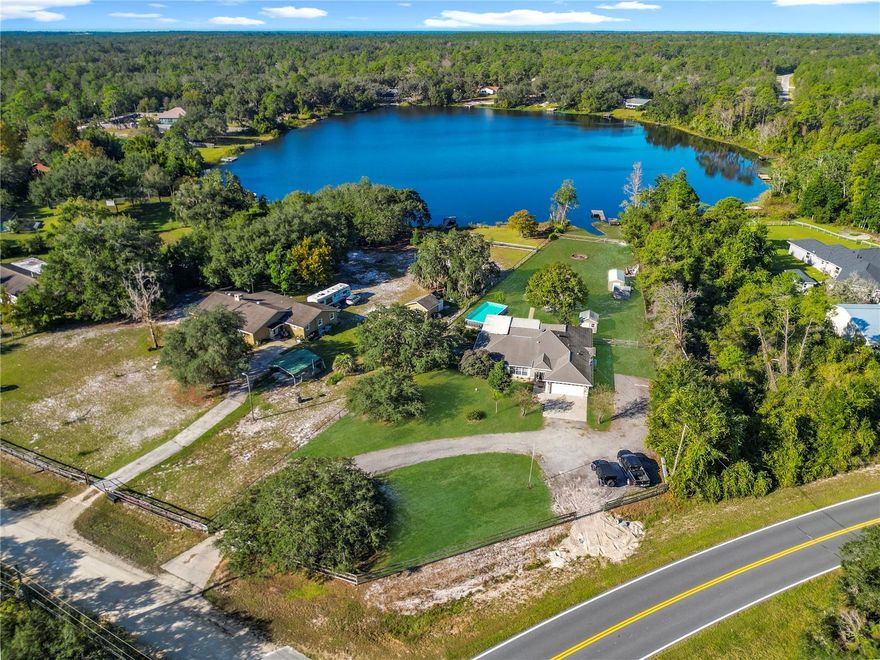 Your Florida lakefront dream property is here! Nestled near the picturesque Ocala National Forest, this home is a true gem. Enjoy the peace and tranquility of spring-fed Bear Lake right in your backyard with the option to fish or kayak year round. The dock is in great shape and offers plenty of space for relaxation and soaking up the sun, plus the owner is installing a floating dock! Step inside to discover a spacious interior with a well thought out floor plan that ensures privacy for all family members, while the design seamlessly integrates the living, dining, family room Florida room and kitchen areas. The heart of the home boasts an updated kitchen equipped with stainless appliances, perfect for culinary enthusiasts and entertainers alike. The kitchen features an abundance of cabinet space, and beautiful stone countertops, matching granite throughout. The cozy family room features a gas fireplace with stone tile surround. The master bedroom features a large walk through closet with attached custom dressing room. The spacious master bath has double vanity and jetted tub. Property is fenced, with a gated entry and plenty of parking. Spend evenings by the fire at the dedicated fire pit area gazing at the sunset reflecting on spring fed Bear Lake. Or you can relax in the hot tub, then take a dip in the huge above ground pool, featuring nice wide steps in and out of the pool. There are 2 legal anchored down sheds in the backyard. One is 14' x 16', and the other is 14' x 24'. Plenty of room for tools and storage. Too many details to list, come see for yourself. This is more than a home; it's a lifestyle. Don't miss the chance to make it yours! *Grass has been retouched/edited in the photos.