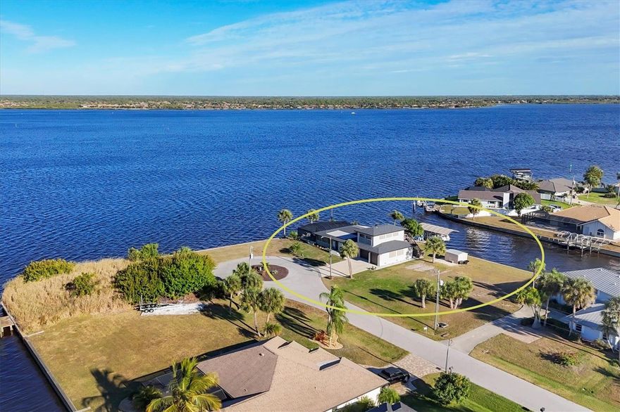Here is your opportunity to wake up every day feeling like you’re on vacation in your own private waterfront resort in Gulf Cove on the Myakka River. This exceptionally updated 4 BEDROOM, 4 BATH, 4-CAR GARAGE POOL HOME includes an upstairs STUDIO APARTMENT / IN-LAW SUITE and delivers breathtaking panoramic water views from nearly every room. And for boating enthusiasts seeking space, flexibility, and exceptional waterfront frontage, the buildable adjacent lot is included, creating a rare 0.65-acre oversized DOUBLE WATERFRONT TIP LOT with over 280 feet of concrete seawall. With expansive water frontage wrapping around the property, you’ll have the freedom to design the ultimate waterfront lifestyle— whether that means expanding the existing home, adding outdoor living space, or simply enjoying the unmatched space and separation that few properties can offer. Extensive 2023 upgrades include NEW ROOF, new pool cage, expanded 6-CAR CONCRETE DRIVEWAY, additional bedrooms and baths, and a newly constructed 900 S.F. AIR-CONDITIONED 4 CAR TANDEM GARAGE equipped with a 12,000-lb vehicle lift, upgraded 220 electric with a 100-amp panel, overhead storage, utility sink, and insulated hurricane-rated doors with battery backup. The STUDIO APARTMENT above the garage was just completed in 2023 and offers water views, its own entrance, and exceptional flexibility—ideal for extended family, guests, multi-generational living, or the opportunity to generate rental income. The STUNNINGLY SPACIOUS MAIN HOME features HURRICANE-IMPACT WINDOWS AND DOORS and showcases a newly remodeled entertainer’s kitchen featuring new cabinetry and granite countertops, anchored by an oversized granite island and complemented by a wet bar, creating an ideal setting for effortless hosting, serving, and social gatherings. Beautiful travertine flooring, updated lighting, built-in shelving with custom barn door concealing a cleverly hidden desk workspace, and a light, bright interior that flows seamlessly outdoors through an abundance of French and sliding glass doors, maximizing indoor-outdoor living and water views. The outdoor living experience rivals a private resort, featuring a custom SALTWATER HEATED POOL with Baja sun shelf, glass tile accents, Pebble Tec interior, shell stone pavers, and a Clearview screen enclosure providing full waterfront views, complemented by a wraparound screened lanai, screened porch with sweeping river views, and shaded canal-side lounging areas perfect for enjoying sunrise reflections, cooling breezes, and abundant wildlife year-round, including dolphins, manatees, stingrays, ospreys, bald eagles, herons, and more. Enjoy a day on the water with quick access to Charlotte Harbor and the Gulf from your PRIVATE DOCK complete with a 10,000-LB COVERED BOAT LIFT with new motors, new cover, and GEM remote. Additional features include FULL RV HOOKUPS accommodating a 35-foot motorhome, plus a GENERAC GENERATOR with a 500-gallon inground propane tank. Thoughtfully designed for car enthusiasts, avid boaters, and RV owners alike, this exceptional waterfront estate offers remarkable privacy at the end of a cul-de-sac creating a truly rare opportunity. Location, Location, Location – 20 minutes to nearby beaches and attractions: Englewood Beach, Manasota Key, Gasparilla Island, Boca Grande, state parks and trails, golfing, sports parks, fantastic fishing, kayaking, boating, marinas, shopping, dining, and gorgeous sunsets. Call today and start living in PARADISE!