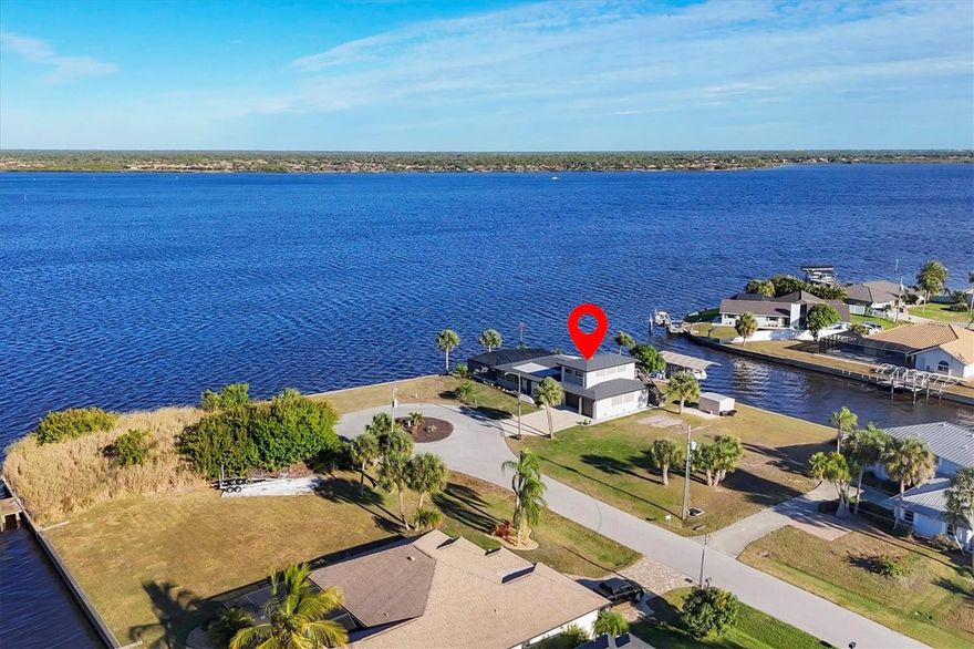 EXPANSIVE WATERFRONT VIEWS from every room create the picture-perfect backdrop to this stunningly open and spacious, REMODELED GULF ACCESS pool home - perfectly positioned on an OVERSIZED TIP LOT with over 200 feet of concrete seawall along the wide-open Myakka River.  Here, each day feels like a vacation in your own private waterfront resort in Gulf Cove — whether you choose sunrise fishing, an afternoon cruise through the harbor, a sunset ride on open water, or simply relaxing poolside overlooking the river.  This beautifully updated 4 bedroom, 4 bath, 4-car garage POOL home includes an upstairs STUDIO APARTMENT / IN-LAW SUITE.  Extensive 2023 upgrades include NEW ROOF, new pool cage, expanded 6-CAR CONCRETE DRIVEWAY, additional bedrooms and baths, and a newly constructed 900 s.f. air-conditioned 4-CAR TANDEM GARAGE equipped with a 12,000-lb vehicle lift, upgraded 220 electric with a 100-amp panel, overhead storage, utility sink, and insulated hurricane-rated doors with battery backup.  The studio apartment above the garage was just completed in 2023 and offers water views, its own entrance, and exceptional flexibility—ideal for extended family, guests, multi-generational living, or the opportunity to generate rental income. The main home features HURRICANE-IMPACT WINDOWS AND DOORS and showcases a newly remodeled entertainer’s kitchen featuring new cabinetry and granite countertops, anchored by an oversized granite island and complemented by a wet bar, creating an ideal setting for effortless hosting, serving, and social gatherings. Beautiful travertine flooring, updated lighting, built-in shelving with custom barn door concealing a cleverly hidden desk workspace, and a light, bright interior that flows seamlessly outdoors through an abundance of French and sliding glass doors, maximizing indoor-outdoor living and water views. The outdoor living experience rivals a private resort, featuring a custom SALTWATER HEATED POOL with Baja sun shelf, glass tile accents, Pebble Tec interior, shell stone pavers, and a Clearview screen enclosure providing full waterfront views, complemented by a wraparound screened lanai, screened porch with sweeping river views, and shaded canal-side lounging areas perfect for enjoying sunrise reflections, cooling breezes, and abundant wildlife year-round, including dolphins, manatees, stingrays, ospreys, bald eagles, herons, and more. Enjoy fishing or a day on the water with quick access to Charlotte Harbor and the Gulf from your PRIVATE DOCK complete with a 10,000-LB COVERED BOAT LIFT with new motors, new cover, and GEM remote. Additional features include FULL RV HOOKUPS accommodating a 35-foot motorhome, plus a GENERAC GENERATOR with a 500-gallon inground propane tank. Thoughtfully designed for car enthusiasts, avid boaters, and RV owners alike, this exceptional home offers remarkable privacy at the end of a cul-de-sac. You’ll love living in Gulf Cove, where a lively atmosphere and year-round activities bring neighbors together. Holiday events, festive parades, and golf cart rides add charm, while the community park and pavilion host barbecues and celebrations that make it easy to connect and feel right at home.  Fantastic location – only 20 minutes to nearby beaches and attractions: Englewood Beach, Manasota Key, Gasparilla Island, Boca Grande, state parks and trails, golfing, sports parks, fantastic fishing, kayaking, boating, marinas, shopping, dining, and gorgeous sunsets. What are you waiting for!