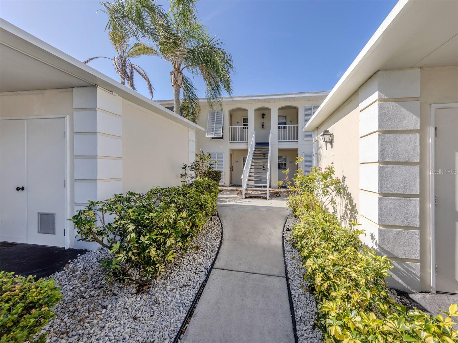 GROUND FLOOR! This updated turnkey, end ground-floor unit in the beautiful community of Plantation Golf and Country Club with beautiful westerly views! This beautifully maintained two-bedroom, two-bath gem spans 1,110 square feet and is brimming with charm. Updates include hurricane windows and doors, 2024 new roof, new carpet and more. The kitchen is a delight featuring solid wood cabinetry, gently used appliances, breakfast bar and sleek granite countertops that make every meal prep feel special. The great room design feels open and flows effortlessly, creating a cozy yet spacious vibe for everyday living and includes your dining room area and living space. The primary suite is on the front of the home and includes a delightful nook that bathes in natural sunlight with walls of windows. This nook extends the primary’s cozy retreat, offering a bright and airy space where you can sip your morning tea, read a favorite novel or simply soak in the warmth of the Florida sun. This spacious primary also includes a built-in desk, large walk-in closet and private en suite with tall cabinetry and walk-in shower. Toward the back of the home, you will find the spacious and bright second bedroom with built-in closet and sliding glass door access to the lanai and near the second full bath making this a tropical oasis for guests. Step outside to enjoy golf course views that add a touch of serenity or relax on the screened lanai or open outdoor patio, both boasting westerly-facing views for those dreamy Florida sunsets. The laundry room is conveniently on the lanai in the large storage closet. Including a covered carport and storage room, ideal for your golf clubs and beach chairs. Steps away, the community heated pool, clubhouse and numerous grilling stations. Membership at the Plantation Golf & Country Club is optional. The club offers two golf courses, tennis, pickleball, fitness and dining. The well-established, amenity-rich Plantation development is conveniently just minutes to pristine beaches of the gulf, downtown Venice, Atlanta Braves Spring Training Cool Today Park, new downtown Wellen Park, shopping, new Sarasota Memorial Hospital and dining.
