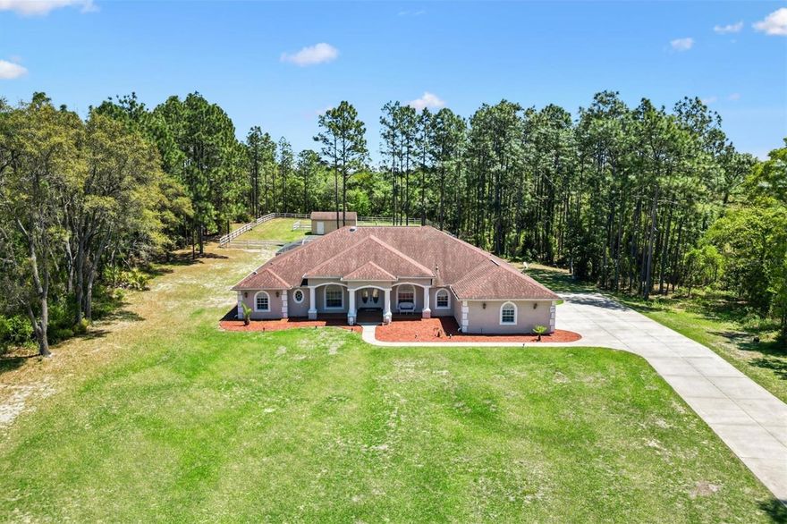 What a rare and enchanting opportunity for equestrian enthusiasts seeking the perfect blend of country charm and modern comfort, ideally situated in BEVERLY HILLS within the sought-after community of Pine Ridge Estates, and conveniently located within reach of both Tampa and Ocala. Nestled on 2.75 beautifully maintained acres, this captivating mini horse farm invites you to embrace a peaceful, pastoral lifestyle without sacrificing convenience.  The heart of the property is a thoughtfully designed one-owner home, built in 2010 with  CONCRETE/BLOCK/STUCCO construction, offering 3,436 square feet of living space under air. Inside, elegance meets comfort with soaring 10-foot tray ceilings, enhanced by solar accents and soft recessed lighting that create a warm and inviting ambiance throughout. Every detail has been carefully considered to provide both style and function.  Step outside and discover your own private oasis, where a HEATED SALTWATER POOL shimmers beneath a screened birdcage, offering year-round enjoyment powered by an UNDERGROUND 500-gallon PROPANE TANK that also services the GAS RANGE. Whether you're entertaining guests or enjoying a quiet Florida evening, this outdoor retreat is nothing short of magical.  Equestrian dreams come to life with a fully FENCED PASTURE measuring approximately 125 by 149 feet, complete with a charming 2 STALL BARN featuring convenient walkout access. The acreage provides ample space for your horses to roam, while still maintaining a manageable footprint for ease of care. A dedicated WELL supports the irrigation system, while the home itself benefits from CITY WATER, giving you the best of both worlds.  Additional Features include a spacious 3 CAR GARAGE,  SECURITY ALARM SYSTEM for peace of mind, and a luxurious 2 PERSON NORDIC INDOOR SPA, perfect for unwinding after a day spent outdoors.  This is more than just a home, it’s a lifestyle filled with serenity, beauty, and the simple pleasures of country living. Opportunities like this are few and far between, so don’t let this one slip away. Act now and make this enchanting equestrian retreat your very own.