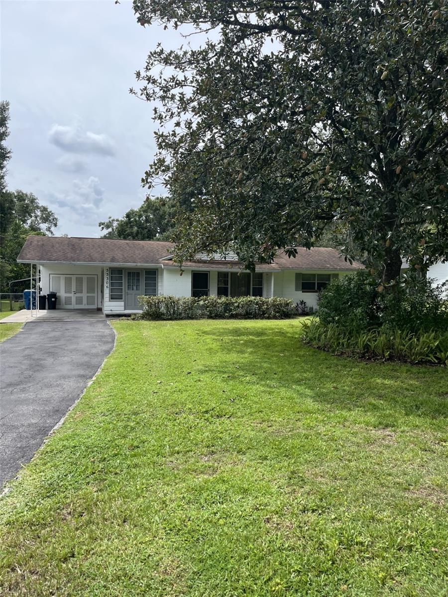 Great opportunity to purchase this older well built home in perfect location to commute to Tampa, Orlando and Ocala areas. This 2/1 bath home offers a Florida room along with a 12x19 screen porch over looking a large fenced in rear yard. This property offer a 1/2 acre shaded lot. Home offers a living room with fireplace, dining area, kitchen with wood cabinets, Florida room with lots of windows for natural lighting, carport with attached workshop/utility room. Roof was replaced in 2019. Great starter home or perfect winter residence.
