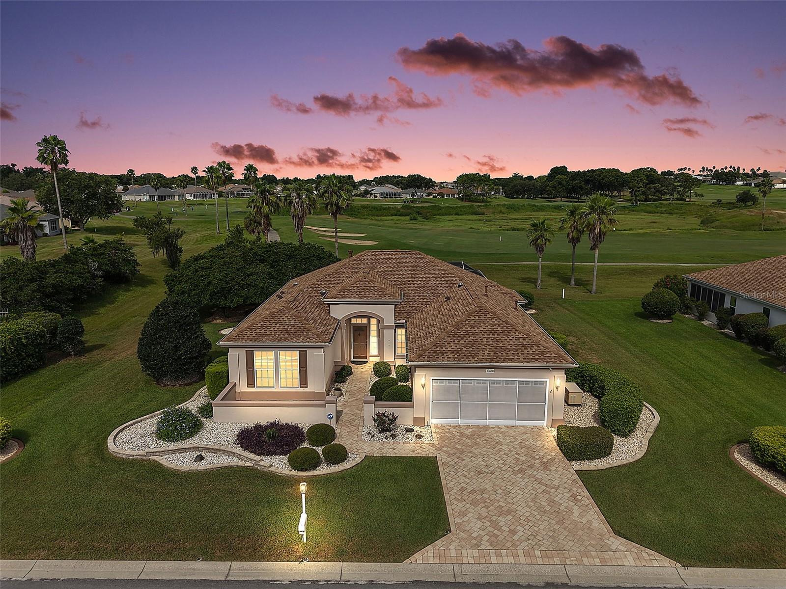 EXQUISITE, GOLF FRONT 2/2 +DEN, Madeira Model featuring a FABULOUS 340sf UNDER-AIR ENCLOSED LANAI with adjacent 700sf NEWLY SCREENED PORCH and OVERSIZED garage in the quaint village of Reston in the GATED community of Del Webb’s Spruce Creek! NO BOND! The ELEGANT exterior of this lovely home boasts PAVER drive and walk ways, MATURE landscaping with CURVED, TIERED walls and STONED beds, and a FABULOUS front sitting area with a decorative hacienda wall. A covered entry and front door with retractable screen, and etched glass side lite and transom window welcome you into the BRIGHT foyer featuring a decorative display niche. 10’ HIGH ceilings, TILE flooring and a SOLAR TUBE grace the VOLUMINOUS living, dining, and kitchen areas. The OPEN-CONCEPT floor plan offers a SPACIOUS layout that connects these rooms for effortless entertaining and everyday living. A STRIKING BUILT-IN entertainment unit with a plethora of shelves and a COZY GAS FIREPLACE is the focal point of the living room. The STUNNING kitchen features GORGEOUS WOOD cabinetry with pull-outs, CORIAN countertops, STAINLESS appliances, PANTRY closet, under-cabinet LIGHTING, EAT-IN breakfast bar, and an adjacent OFFICE area with built-in DESK and additional cabinets. The lovely dining room boasts a bay window with STORAGE seat. From the dining room, sliding glass doors invite you in to the FABULOUS 34’x10’ UNDER-AIR ENCLOSED LANAI with CROWN MOLDING and GORGEOUS LUXURY VINYL PLANK floors. This AMAZING ROOM offers 340sf of ADDITIONAL LIVING SPACE! Step through an exterior French door into the adjacent 34’x20’ EXPANSIVE, PAVERED, SCREENED PORCH overlooking three different golf holes of the Masters #2 Golf Course! This SPACIOUS RETREAT is perfect for RELAXING with your morning coffee, HOSTING friends and family, or simply ENJOYING the beautiful Florida weather! Back inside, retreat to the primary bedroom boasting golf front views, a bay window with STORAGE seat, French door to the lanai, and generous CUSTOM WALK-IN closet with SOLAR TUBE, and FLOOR SAFE. Its en-suite bathroom features a WALK-IN THERAPEUTIC WHIRLPOOL TUB, WOOD cabinetry with DOUBLE sinks, separate water closet, LINEN closet, and TILE floors. The second bedroom offers DOUBLE windows and a built-in closet. Bathroom two features WOOD cabinetry, combination tub and shower, TILE flooring, and hallway LINEN closet. There’s also a DEN/OFFICE with CROWN MOLDING and TILE floors located just off of the foyer behind POCKET doors. ADDITIONAL FEATURES include a PRIVATE irrigation well and a WHOLE HOUSE Generac GENERATOR. Completing the package is an OVERSIZED 20’x27’ 2-car garage with EPOXIED floors, shelving, ceiling fan, and SLIDING SCREEN DOOR PANELS. Del Webb’s Spruce Creek is a 24-HR GUARD-GATED, 55+ COMMUNITY just 4 miles north of The Villages! Enjoy resort-style indoor and outdoor pools, state-of-the-art fitness center, golf, tennis, pickle ball, bocce, softball, billiards, a ballroom, and more than 100 clubs and activities! PLEASE WATCH OUR WALKTHROUGH VIDEO OF THIS FABULOUS GOLF FRONT HOME and call today to schedule your Private Showing or Virtual Tour!