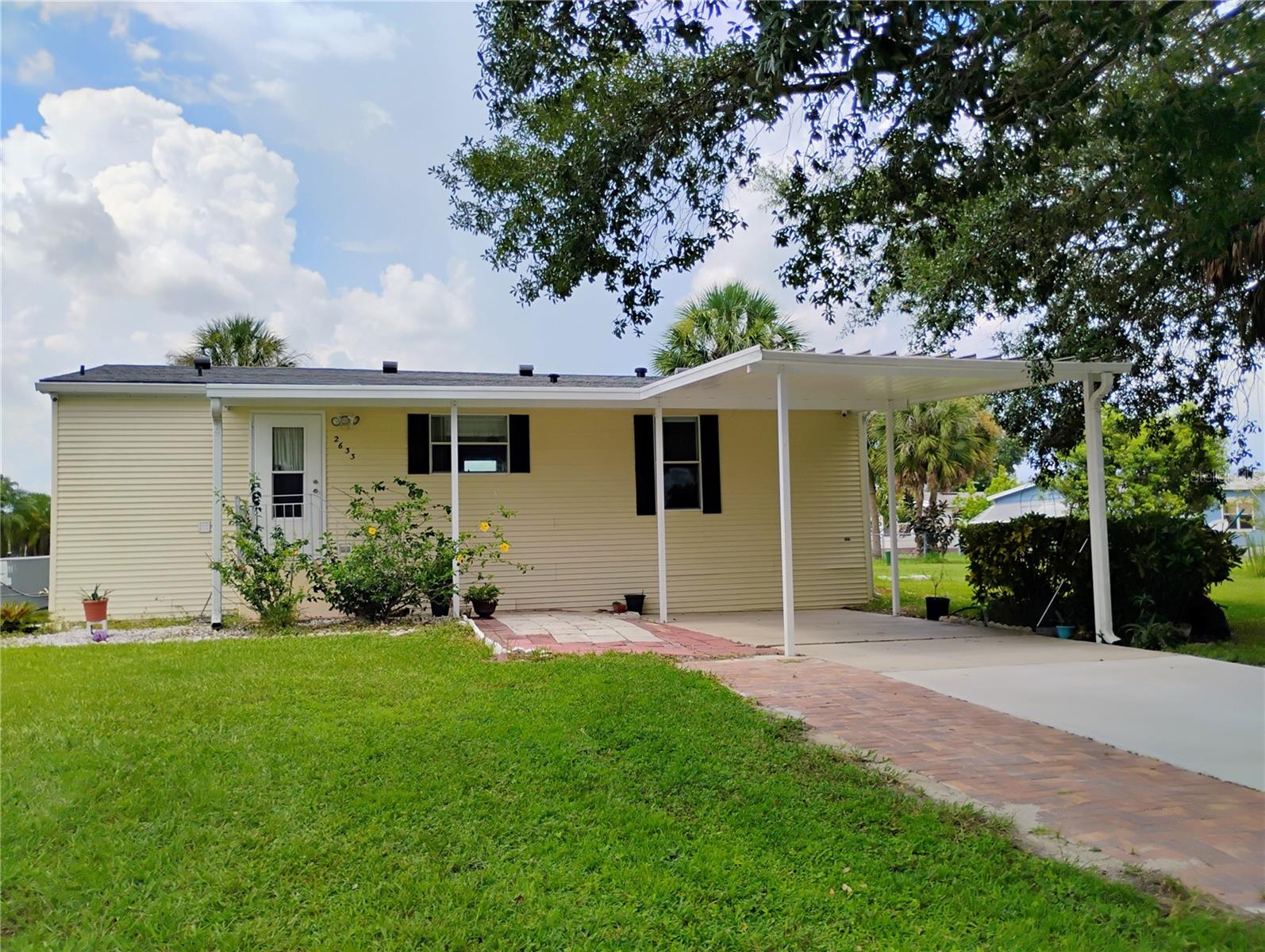 2005, Palm Harbor, Open Plan Doublewide 3/2 Bristol Model nestled in the Serene Broadmoor community where you Own your Land. Newer Roof, A/C (Less than 4 years) Driveway + added pavers for wider driveway, and Back patio is less than 6 months old. Breathtaking Water Views can be seen throughout the home all the way from the spacious Open plan Kitchen which boast, Granite Countertops and a Breakfast Bar. Both upgraded bathrooms have Granite countertops, the whole house has either a tile or Laminate floor, and some rooms have been freshly painted. Community offers a beautiful Large Swimming pool, Clubhouse, Tennis, Volleyball, Basketball, Bocce Bowling, Shuffleboard and more, for a fun, active lifestyle. HOA fees cover, cable, internet, and lawn care. You are close to great schools, shopping, medical, dining, attractions, Kissimmee Lakefront/Downtown and Poinciana Sun rail. Included are exterior security cameras, security monitor and an NVR with 1 terabyte of memory. One year home warranty is provided with an acceptable offer.
