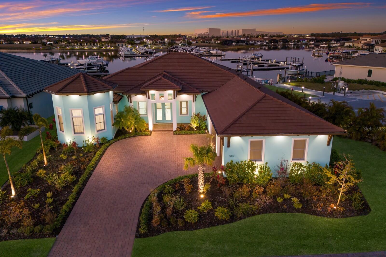 DREAMING of FLORIDA WATERFRONT LUXURY LIVING? Boating, sunsets, fun and so much more on the majestic Manatee River.
This beautiful CUSTOM home is located in the "Waters Edge" enclave of Sanctuary Cove offering a premier private marina, 8,000+ square foot clubhouse/pool, gated security and private beach. Completed in 2023 the Open Concept 4-bedroom 4.5 bath with 2 offices/dens surrounding a stunning large living area, an inspiring gourmet kitchen with breakfast bar seating for eight and elegant dining room-all overlooking the private marina and resort style pool. A 24ft wall of glass pockets to incorporate 2,000+ square feet of outdoor paradise. Words cannot describe the Entertainer's Outdoor kitchen feature. Seating for 14, a raised bar includes beverage station with sink, ice maker, 2 bar refrigerators, custom lighting and a gourmet grilling arrangement. A sparkling heated pool/spa with spacious area for sunbathing or spectacular sunset gazing. Separate pool bath and designer lighting enhance the view of the Sanctuary Cove marina and your private boat slip and dock. Split resort style guest bedrooms each with ensuites. The primary suite offering a private haven and lanai access. Primary suite features include a dressing area, tray ceiling with indirect lighting and custom closet solutions. Work from home with two offices, one with 14' high ceilings and custom built in features. Recessed niches, beautiful decor features, extensive woodwork, tray ceilings and lighting enhancements make this home truly one of a kind. Rest assured this newer above flood zone "smart" home features builder's warranty, hurricane-impact windows & doors, stunning exterior lighting & landscape upgrades. No flood insurance required here! A short stroll to the private beach and BBQ area. Meet your neighbors at the beautiful clubhouse and pool. A short boat ride brings you to the Gulf and beyond. Conveniently located near major international airports, world class beaches, professional sporting events and fantastic fishing. The area features over 35 golf courses. From public to the Ritz Carlton. Tampa Bay, Sarasota and St. Pete all less than 45 minutes away. Upon arrival command Alexa to enhance your visit. A list of designer features and upgrades are available. Alert: Price Break.