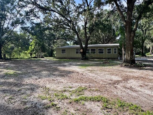 Private Triple-Wide Mobile Home on Nearly 2 Acres – No HOA or CDD
This spacious and secluded triple-wide mobile home offers privacy, flexibility, and extensive upgrades.
Features include a tin roof, wood siding, sunroom, and luxury vinyl flooring. A new A/C unit and a fully updated master bathroom — including a tiled shower — were completed in 2021.
The home boasts a modernized kitchen with new cabinets, countertops, and appliances. The second bathroom has been refreshed with new flooring, fixtures, toilet, and shower approximately $20,000 in updates.
The property is equipped with a well and two septic tanks. A second mobile home previously occupied the site, leaving an additional electric pole and septic tank — perfect for adding a 900 sq. ft. guest house with little to no impact fees (verify with county).
Enjoy as-is, add a guest house, or build your dream home with a pool and pool house. This versatile property is a rare find with no HOA or CDD. owner is FL licensed agent