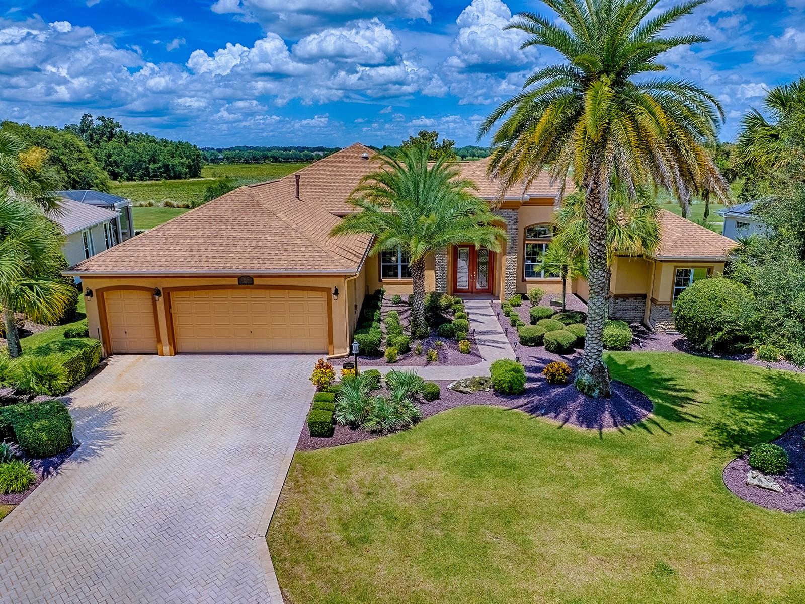 SPECTACULAR EXPANSIVE GOLF COURSE VIEW on this CUSTOM ST. JOHNS PREMIER home situated on the 2nd hole of RILEY, with spacious outdoor living space, a POOL, and decorative POND and WATERFALLS located in the Village of BRIDGEPORT AT LAKE SUMTER. LOVELY curb appeal with all new rocks in beds, pavered walkway, and custom STONE entrance. Beautiful LEADED GLASS double front doors open to spacious but COZY living and dining room with LUXURY VINYL PLANK FLOORING, lovely architectural features and transoms over the French doors and large picture window that looks out to the AMAZING PANORAMIC VIEW. Through the archway, you’ll find a casual dining area that also looks out over the view with easy access to the kitchen. The kitchen has lovely GRANITE counter tops, mosaic tile backsplash, accented with under cabinet lighting, BLACK STAINLESS newer appliances with GAS stove with DOUBLE OVEN, an island, upper and lower pullout drawers, and a large WALK-IN PANTRY! You’ll love the BONUS room which is set up as a BAR for a great place to entertain, play cards, etc. while enjoying the view through another large picture window! This area can be used as a den, library, whatever works well with your lifestyle! You can access the POOL area from this room and also the living room to enjoy the large lanai, POOL, and a VIEW that offers no homes anywhere in sight as you cast your eyes out over this beautiful course. The primary suite offers a spectacular view, plenty of room for a sitting area, 2 large WALK-IN closets with built-ins, and an EN-SUITE bath with dual sink vanities, a claw foot bathtub, brass fixtures, large WALK-IN ROMAN shower with frameless glass, and a separate, private toilet room. The guest rooms are on the opposite side of the home for lots of privacy for all. Both guest rooms have large WALK-IN closets and a Jack-in-Jill bath. The 2nd guest room has a QUEEN MURPHY BED, built-in desk, and like the rest of the home, a spectacular VIEW! The guest bath offers a lovely tiled shower with FRAMELESS GLASS DOOR. In the hallway outside the 1st guest bedroom you’ll find the large LAUNDRY ROOM with tons of counter space, cabinets, a large storage closet, and FRONT LOAD washer and dryer on pedestals that do convey with the home. In the hallway that leads to the garage is a convenient HALF BATH – convenient for all! The LARGE 2 CAR + TANDEM GOLF CART GARAGE can easily hold 2 cars and 2 golf carts with still plenty of room for all your toys, and there are plenty of storage cabinets! NEWER ROOF, 2019 HVAC, and 2020 HOT WATER HEATER! This is a great location surrounded by beautiful golf courses, and right around the corner from Lake Sumter Landing. The Bridgeport Village Recreation Center is close by, and a great place to enjoy time with friends or family. Easy access to the Arnold Palmer Legends Country Club, where indoors or out, the restaurant prepares fine cuisine daily and golfers are sure to enjoy the challenge provided by 27 holes of championship golf. COME SEE ALL THIS LOVELY HOME HAS TO OFFER!