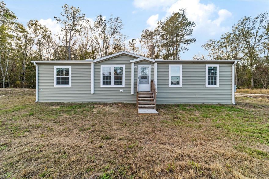 Beautiful 3/2 PLUS OFFICE and it's BRAND NEW! This 2024 manufactured home is located 10 mins from the World Equestrian Center, 15 mins to Rainbow Springs State Park and an easy commute to both Ocala and Dunnellon. Move-in ready home features a spacious split floor plan with 1404 sq ft of comfortable living space all on a 1/4 acre lot. Modern finishes include LUXURY vinyl flooring and CROWNN MOLDING throughout, beadboard walls in dining area, recessed lighting in kitchen with a functional island for seating and storage! The primary suite offers a glass enclosed TILE SHOWER w/ rainwater shower head, garden tub, dual sink vanity and walk-in closet. The two guest bedrooms have built in closets and are convenient to the shared bath w/ linen cabinet in the hall. The additional Office/Den could serve as a 4th bedroom if needed. Just off the kitchen is the laundry room with built in cabinets and back door entry. Home is on a corner lot with woods in back. Side entry driveway, well, septic, central AC...it's all there and ready to be used by you!