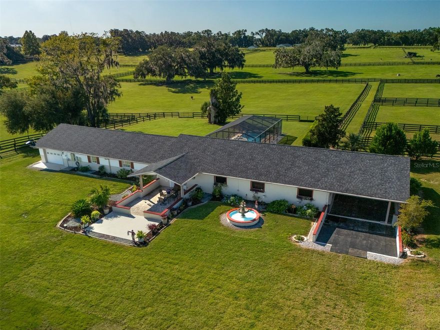 Welcome to Fox Squirrel Farm, a beautifully maintained 10-acre property located in the Cardinal Hill Complex in North Ocala. Just 20 minutes from the World Equestrian Center, this fully fenced farm offers a peaceful, private setting shaded by majestic oak trees and accented with fruit trees and lush green paddocks. The property features a 7-stall concrete block barn, thoughtfully connected to the main residence and equipped with individual stall fans, hot water, and a full-house generator that powers both the home and barn. The charming 2-bedroom, 1-bathroom home boasts parquet and tile flooring, and opens to a screened outdoor lounge area through sliding glass doors. Perfect for relaxation or training, the backyard features a 5-foot deep endless lap pool with heating and cooling capabilities. You'll also find a workshop with attached wash racks, an equipment pole barn, and a 1-car garage. Solar power adds to the efficiency and sustainability of this well-appointed farm, making it a rare opportunity for equestrian enthusiasts seeking both convenience and tranquility in the heart of Marion County.