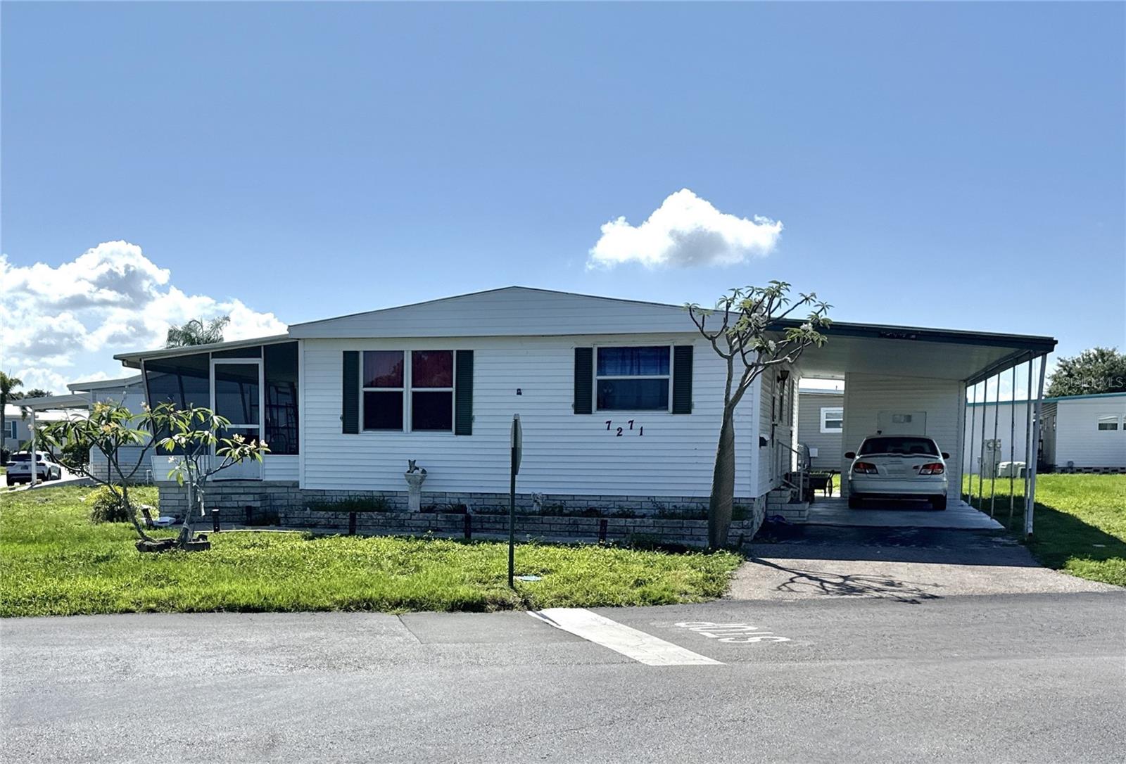 Calling all remodelers! If you're looking for a great home to make your own, then this is it! Owner says bring offers! No flooding! This 2 bed/2 bath/den home is located on an oversized corner lot across the street from park-like community common area. The home with more than 1,000 sq. ft of living space features newer luxury vinyl waterproof flooring in living area, 2018 A/C with 2024 ductwork and roofover. Large 200 sq. ft. screened lanai to enjoy the outdoors. Large carport holds two cars easily. Home is located in the premier 55+ community of Americana Cove. Low monthly maintenance fee of $380 includes water/sewer/trash pick up/lawn mowing/ private streets/24 hr manned gate and all amenities including heated pool, clubhouse, fitness center and private boat ramps on saltwater canals to Tampa Bay with no bridges! Price includes share for the lot and ownership in the Co-op. Great location only 10 mins from downtown St. Petersburg, 15 mins to two airports and 25 mins to beaches. Community requires 675+ credit score. Two dogs or cats up to 35 pounds are welcomed; 2 pets total each household.