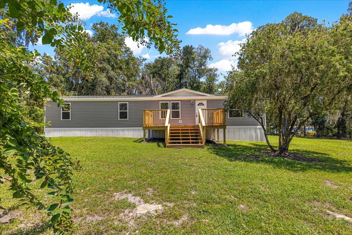 This versatile A-1 zoned 3-acre property in beautiful Belleview offers not one but two beautifully renovated mobile homes, perfect for multi-generational living, rental income, or an Airbnb opportunity. The main home is a 1996 triple wide (1584 sq ft) with 4 bedrooms and 3 bathrooms. The roof is 2018, HVAC, water heater, appliances and cabinets are brand new. The open floor plan features a modern kitchen with granite countertops, gray cabinets and brand new stainless steel appliances. Laundry hook ups are inside for ease of use. This beautiful home has LVP flooring throughout. The siding, windows, and decking are all new as well. Septic was cleaned out in 2023. The second home is a 1971 single wide (744 sq ft). It has 2 bedrooms and 1 bathroom. Completely renovated top to bottom. Featuring granite countertops, new cabinetry and appliances with LVP flooring throughout. This house also has inside laundry hookups. Outside the metal roof, skirting and vinyl siding are all new as well. This mobile home is ideal as an Airbnb, guest house or mother-in-law suite. Both homes have been thoughtfully updated to combine comfort, efficiency, and modern design. With plenty of A-1 zoned land and two move-in ready residences, this property is a rare find with endless possibilities. Come see this property today!