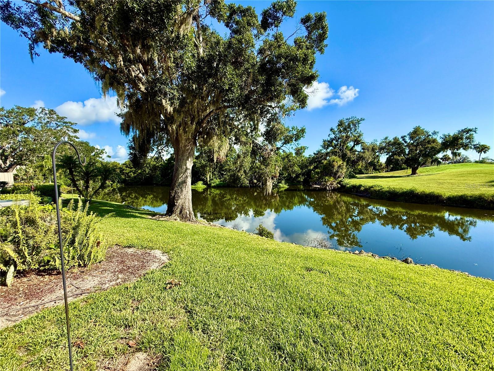 Carefree Living with Gorgeous Water & Golf Views in Hammocks II—A 55+ Gated Oasis!
Welcome to easy, maintenance-free living in the highly sought-after 55+ gated community of Hammocks II at Bent Tree. This beautifully updated, single-story villa offers the perfect blend of tranquility, nature, and comfort—all nestled among moss-draped oaks, peaceful mirror lakes, and the lush fairways of Bent Tree Country Club.
From the moment you arrive, you’ll fall in love with the breathtaking views of the lake, creek, and the 9th hole of the golf course—a picture-perfect backdrop that invites you to relax, unwind, and soak in the Florida lifestyle. Nature lovers will delight in the daily show: otters at play, wading birds, and other native wildlife putting on a “festival of water life” right outside your windows.
Inside, the villa features warm maple wood flooring throughout (no sunken living room here—it’s been raised and refinished!), 42-inch solid wood kitchen cabinets with granite countertops, and updated baseboards for a polished finish. The guest bathroom also includes a stylish tall vanity with granite counters.
The flexible third bedroom has been thoughtfully converted into a cozy TV room—ideal for movie nights or simply kicking back with a good book.
Whether you're teeing off at the country club, enjoying morning coffee with lake views, or heading out in your golf cart to explore the neighborhood, this villa delivers the relaxed, resort-style lifestyle you deserve.