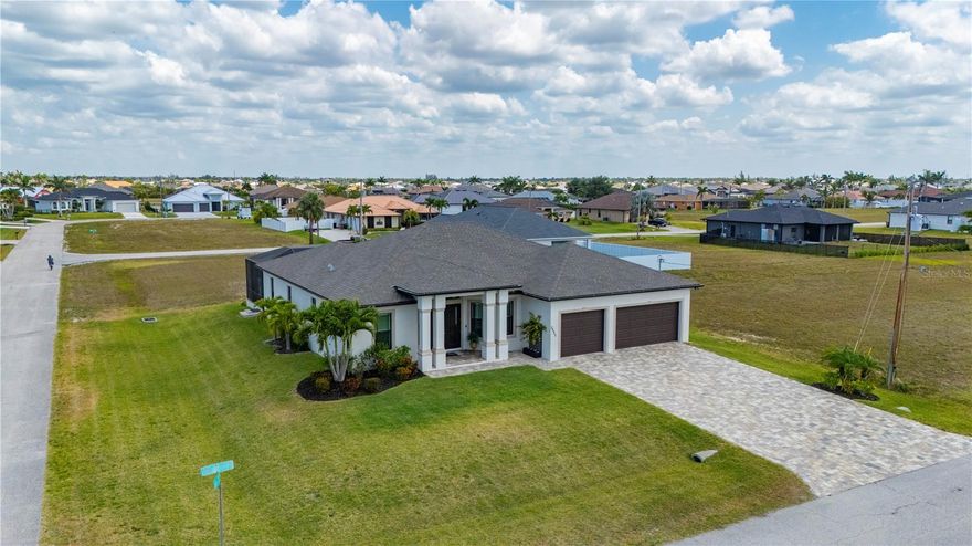 Had appraisal done , Huge $30,000 price reduction . This absolutely stunning 2021 custom-built home offers the perfect blend of luxury, comfort, and thoughtful design. Featuring 5 spacious bedrooms, a dedicated office, 3 full bathrooms, and 2 luxurious primary suites—all situated on a beautifully landscaped double lot with a 3-car garage—this home has room for everyone. As you arrive, a paved driveway leads to elegant double doors, setting the tone for the craftsmanship found throughout. Inside, you’ll find soaring ceilings, 8-foot interior doors, 6-inch baseboards, crown molding, plantation shutters, and 24x24 ceramic tile flowing seamlessly throughout the home. The large living room is ideal for entertaining, with an oversized ceiling fan, and a full wall of impact-rated pocket sliders that open to the screened lanai and pool area.
The open-concept kitchen is a chef’s dream, overlooking both the living room and pool. It features a dramatic 14-foot granite waterfall island with built-in, push-to-open hidden USB outlets, custom soft-close cabinetry that extends to the ceiling, pull-out drawers, and a spacious built-in pantry. All kitchen appliances are still under warranty, offering peace of mind. Both primary bedrooms are retreats in their own right—each with large walk-in closets, private sliders leading to the pool, and spa-inspired en suite bathrooms. The main primary bath boasts a 10-foot walk-around shower with a custom glass backsplash and premium granite finishes. All three bathrooms include walk-in showers with matching granite for a cohesive, elegant look.
Step outside to your private oasis: a spacious 1900 sqft screened-in lanai with beautiful pavers, a custom outdoor kitchen, and plenty of space for lounging or entertaining. The heated saltwater pool features integrated lighting and extra deck space for patio furniture or sunbathing. This home is built to last with impact-resistant windows and doors, a monolithic tie beam for added structural integrity, a whole-house reverse osmosis system, irrigation, and an HVAC system from 2021 that’s been professionally serviced every 6 months.
Every detail of this property was designed with quality, durability, and luxury in mind.  June 19th, 2025 all tiles floors have been professionally regrouted and sealed. This is not just a home—it's a lifestyle.