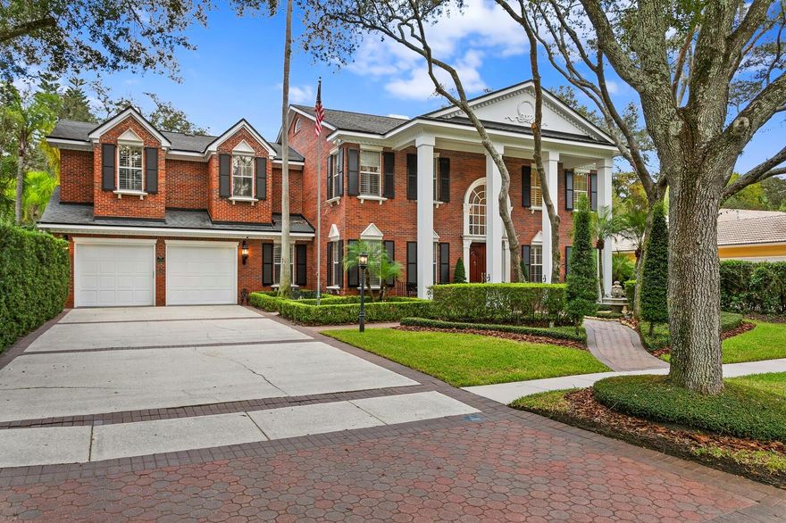 TAMPA PALMS – Live the Tampa Palms lifestyle in this gracious mini estate.  Set amongst a canopy of oaks with grand architecture and park-like grounds, this stately home is a hidden paradise.  Custom built with the finest of detail and character and on .58 sculpted acres, no detail has been overlooked.  With a grand 27-foot entrance foyer, inlaid flooring, modern white accent moldings, a colossal kitchen, a discerning wine room and exquisitely updated throughout, this home artfully bridges refined heritage to modern luxury.  Too many ways to enjoy this marvelous property.  Have quiet mornings on the fireplace patio overlooking the pool and gardens or de-stress with a quick work out and sauna before entertaining guests in extravagant style. Guests may begin by socializing in the club or wine rooms and flow to the outdoors to enjoy the pool and fireplace patios, stroll the garden path, hang out in the gazebo, reflect by the koi pond or watch it all happen from the amazing treehouse!  This home has grand scale but exudes the warmth of a home where many memories are made.  Minutes to the Clubhouse for golf or tennis.  Make Tampa Palms easy lifestyle and this lovely estate property your very own. Please be sure to click on the link to view the video of this beautiful home and grounds.  Conservation lot, cul-de-sac, EV charger, Wolfe, Toto, underground utilities, low HOA fees.  Near USF and Moffitt, parks, beaches and sports venues.