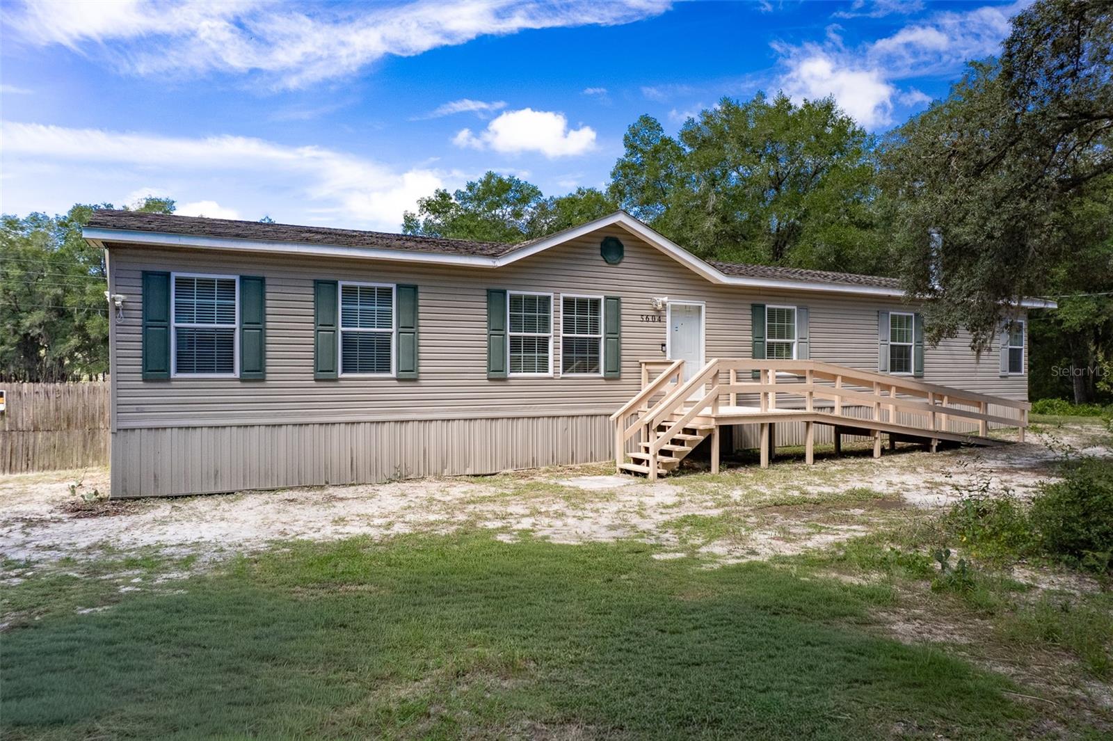 Dreaming of space, comfort, and a touch of country charm? This 5-bedroom, 2-bath beauty in Forest Lake North delivers it all. Set on a high-and-dry 1.26-acre corner lot, you’ll enjoy room to breathe, play, and entertain. Inside, the split floor plan gives everyone their own space, with both a cozy living room and a family room anchored by a wood-burning fireplace, perfect for game nights or holiday gatherings. The kitchen is a true hub with its center island, walk-in pantry, and plenty of storage, and the appliances are barely used thanks to the owners being seasonal visitors. Recent upgrades include new decks, water heater, windows, doors, washer, and dryer. Means less worry and more fun. Step outside and the possibilities are endless: build a pool, plant a garden, or swing under the fruit trees while picking your own plums, limes, and oranges. Need extra space? The 22x25 insulated building on slab is ready for your workshop, hobby space, or oversized storage. This property is a rare find with no HOA restrictions, just freedom to live the way you choose. Perfectly located near restaurants, shopping, and medical facilities, you’ll find daily conveniences close at hand. For those with an adventurous spirit, you’re minutes from the Withlacoochee State Trail for biking and hiking, and a short drive to springs, rivers, and forests for kayaking, fishing, and outdoor exploration. With so much to offer, and the option to purchase furnished, this isn’t just a home, it’s the perfect place to settle your roots and embrace the Florida lifestyle you’ve been dreaming of.